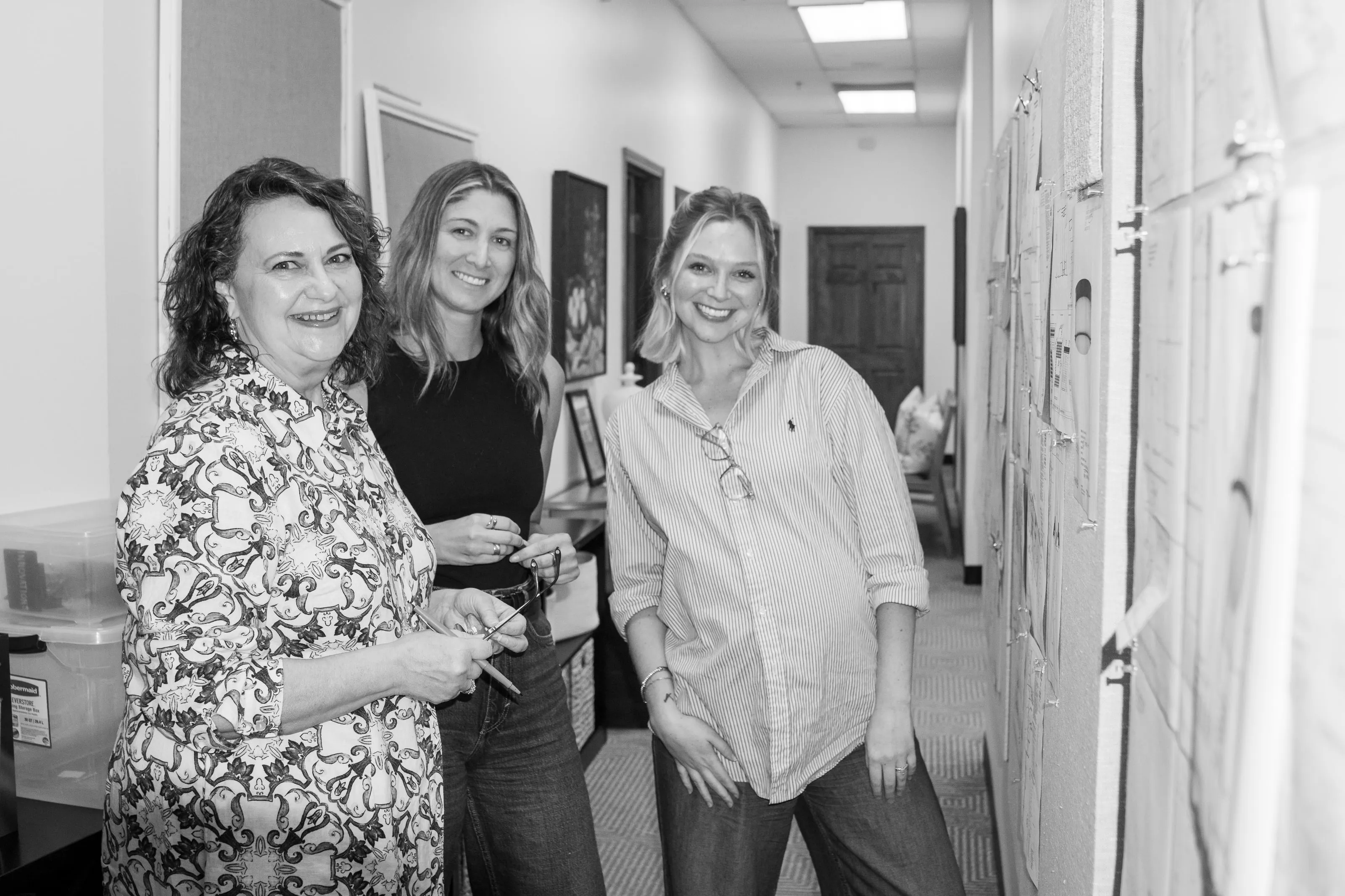 Three members of the Banko Design team in the studio hallway, in black and white