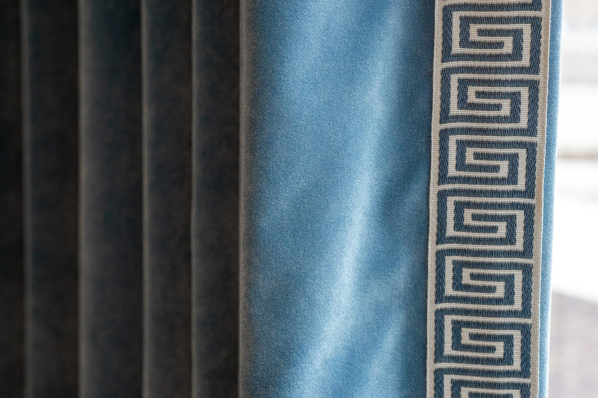 Senior living interior detail: slate blue velvet curtains with a Greek key border, interior design by Banko Design at American House Meridian, Haslett, Michigan