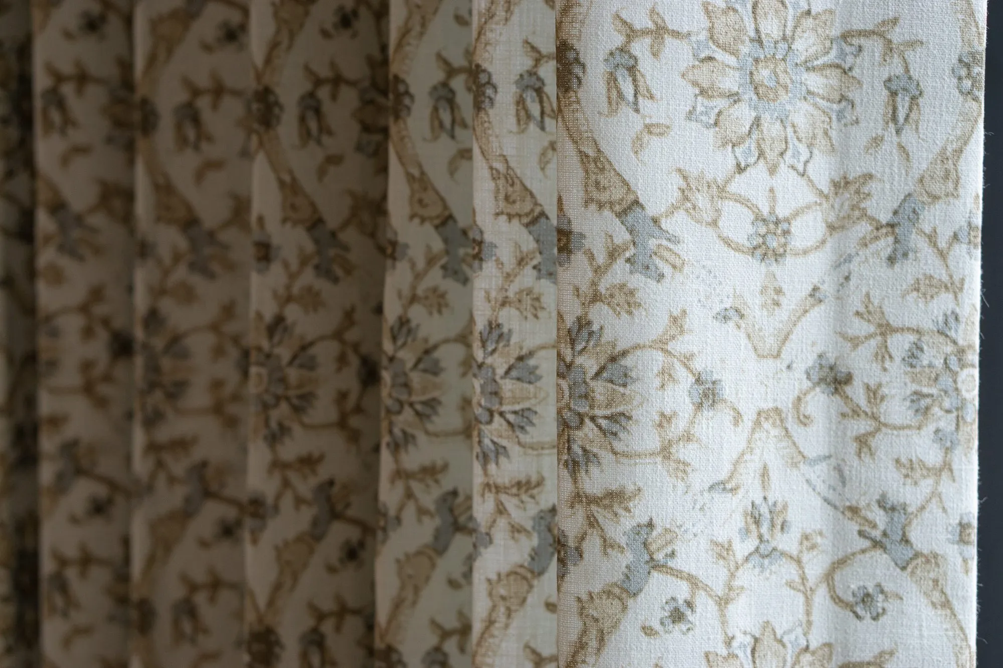 Senior living interior detail: cream curtains printed with a tan and blue botanical pattern