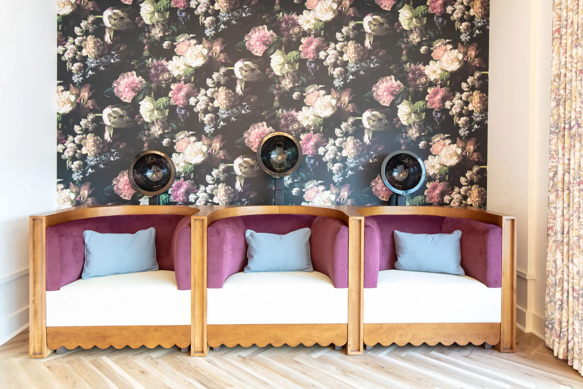 Senior living salon with dryer chairs on a scalloped wood banquette against dark floral wallpaper