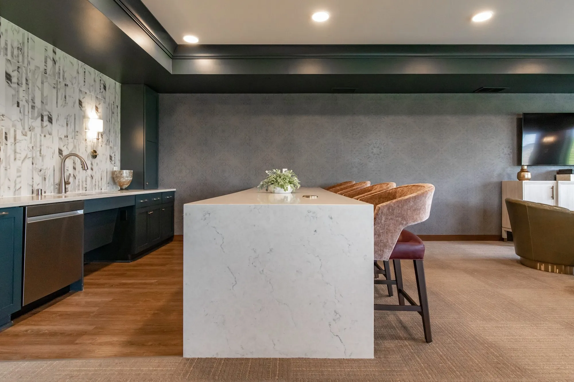 Active adult community kitchenette with a marble waterfall island, interior design by Banko Design at Amira Bloomington, Bloomington, Minnesota