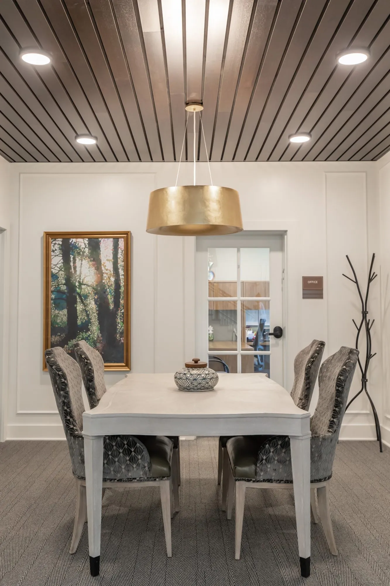Active adult community small dining room with velvet chairs at a whitewashed table under a gold drum pendant