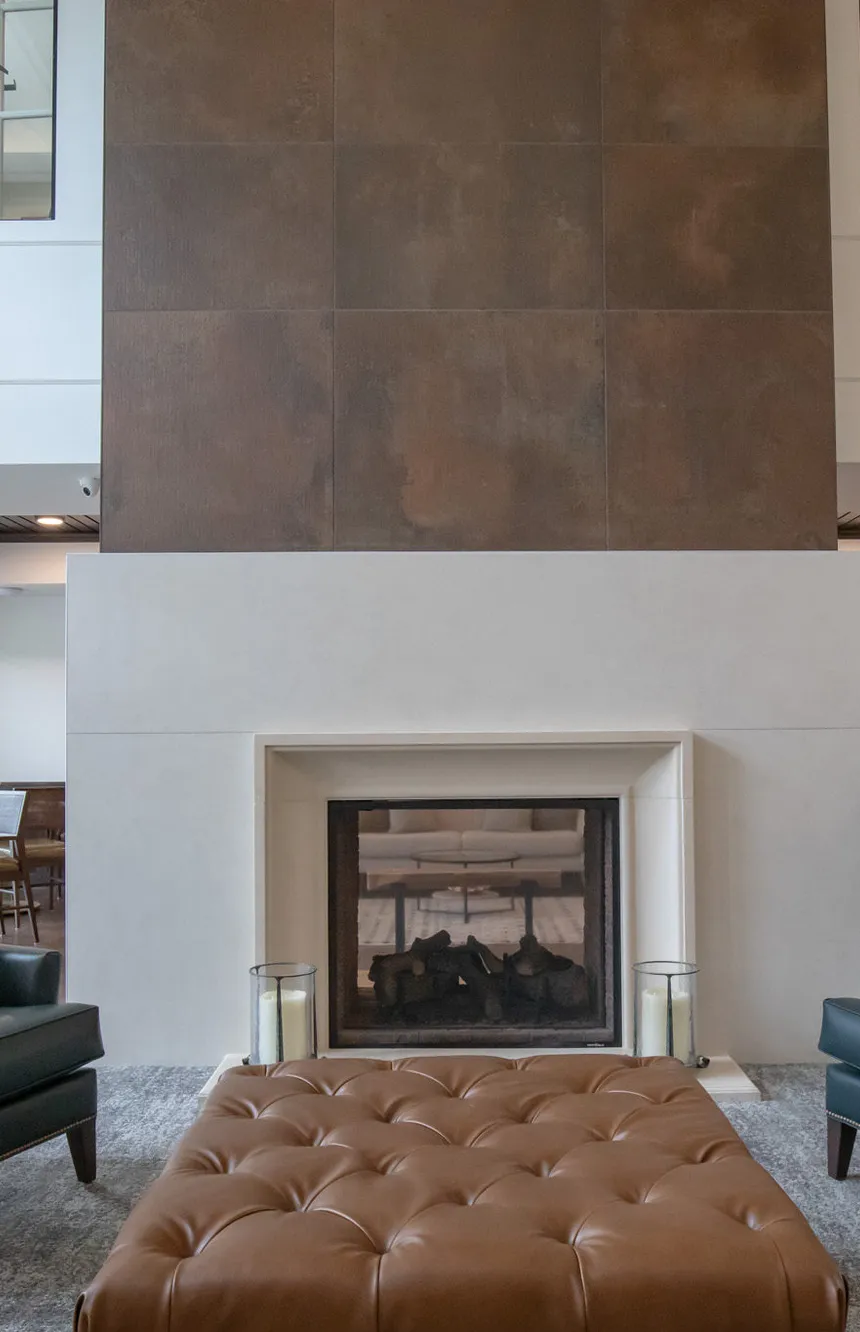 Active adult community two storey lounge with a bronze tiled chimney breast, interior design by Banko Design at Amira Bloomington, Bloomington, Minnesota