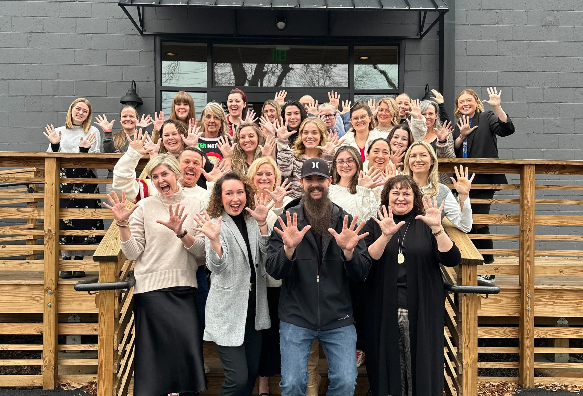 The Banko Design team gathered on the deck outside their studio, holding up ten fingers to the camera