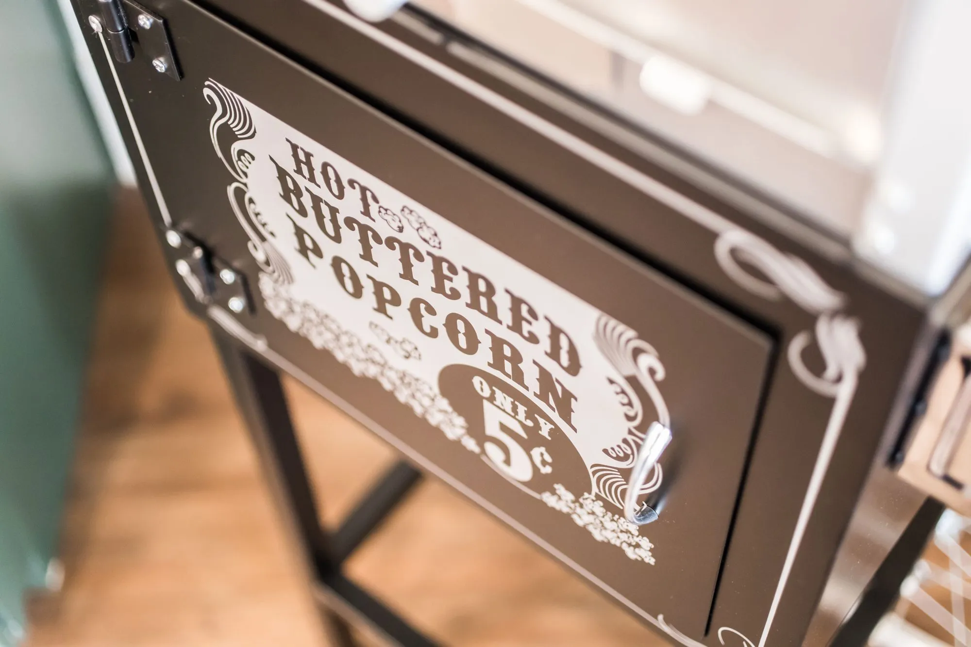 Senior living interior detail: the popcorn cart's lettered panel advertising hot buttered popcorn