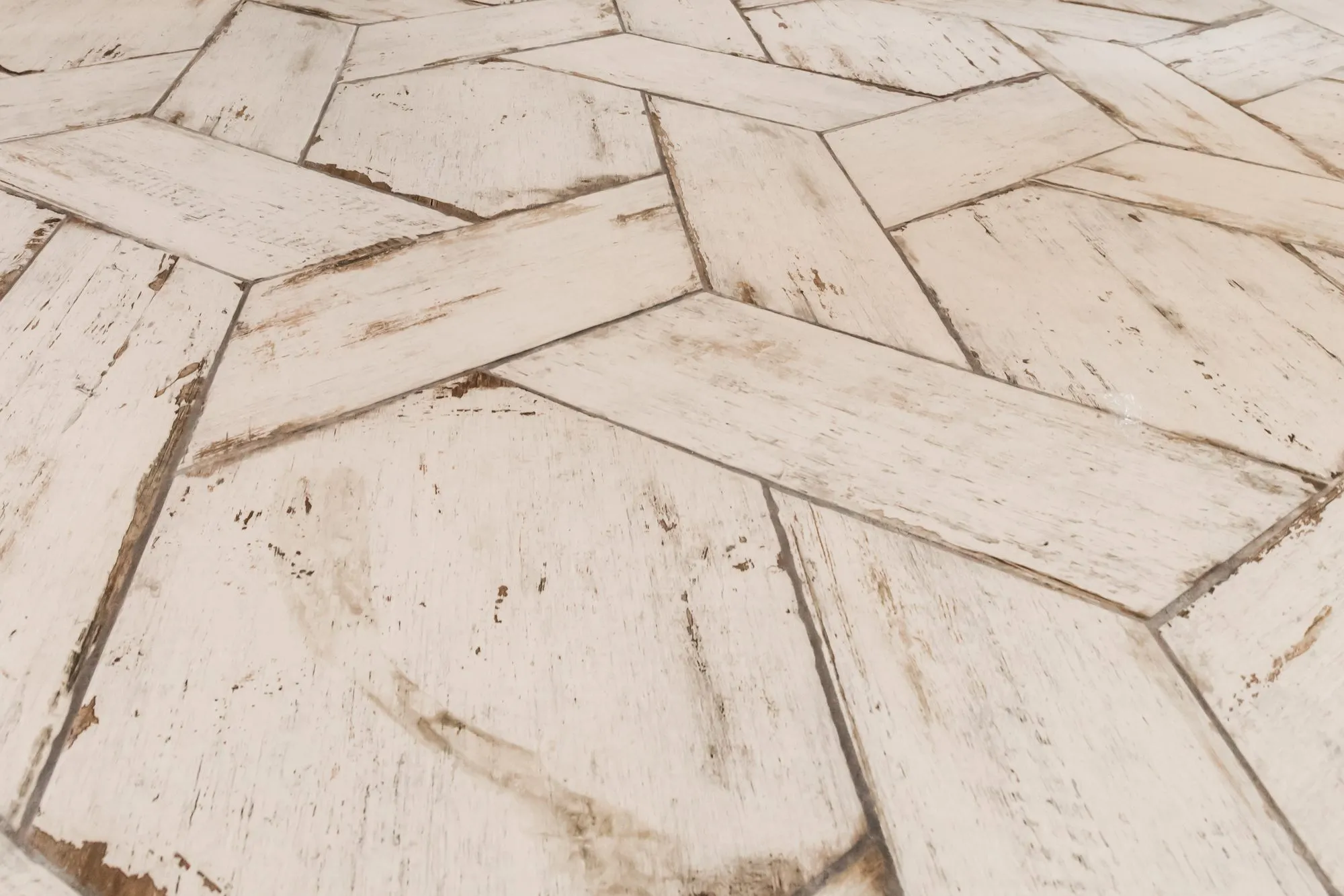 Senior living interior detail: distressed white wood-look tile planks laid in a hexagonal pattern