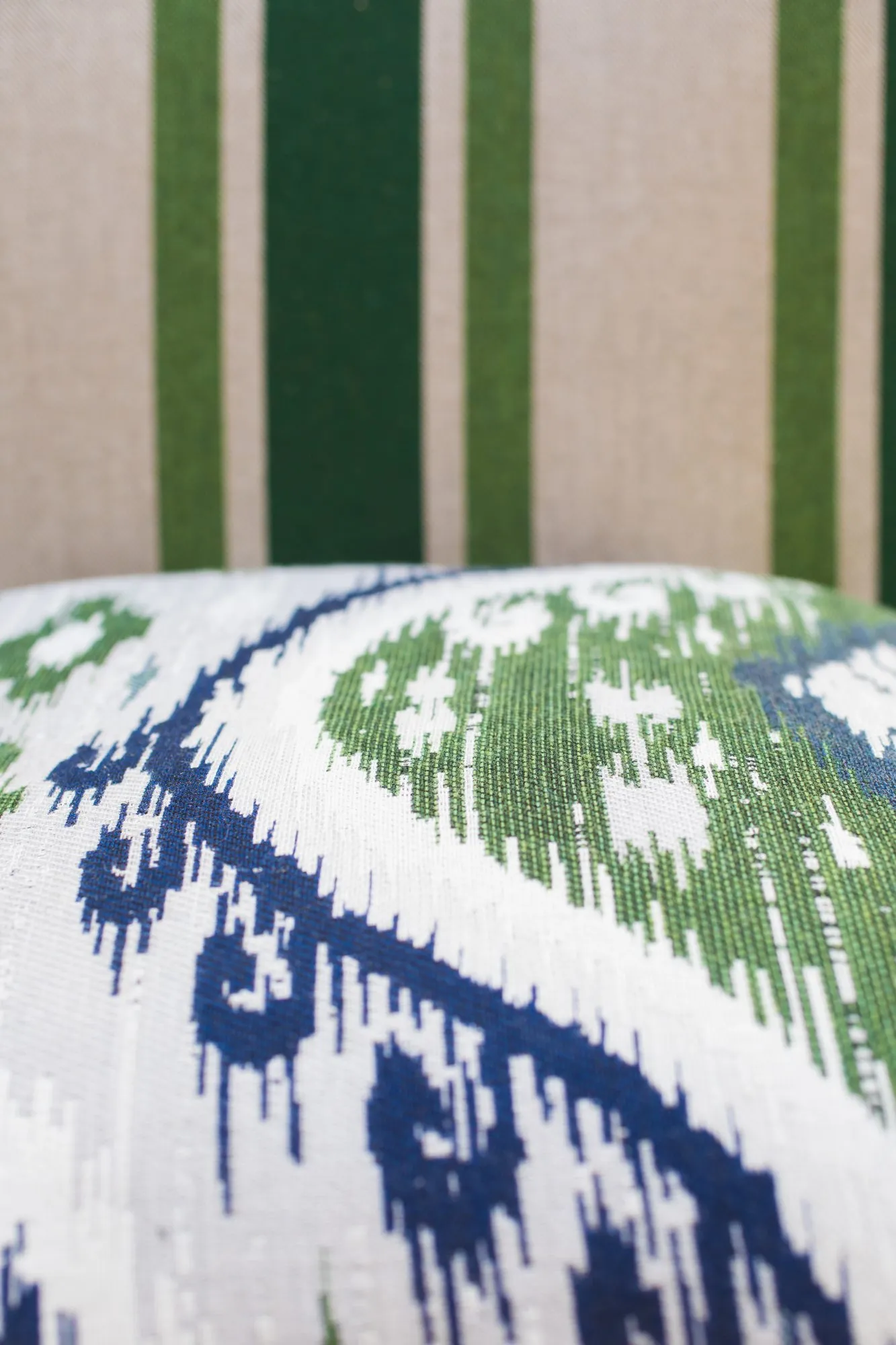 Senior living porch detail: blue and green ikat pillow against green striped upholstery