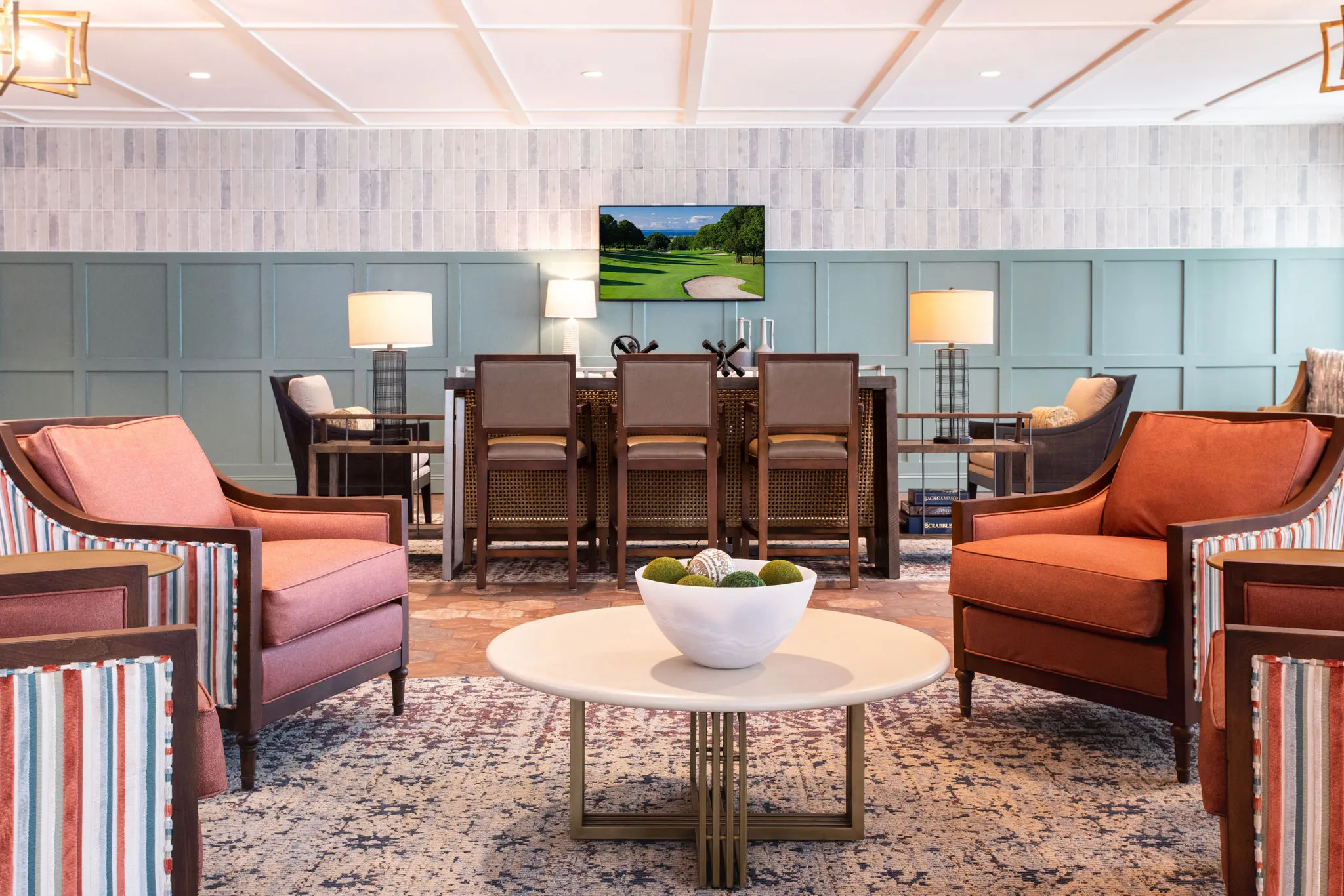 Senior living pub lounge with terracotta armchairs and a cane-back high top against green panelled walls