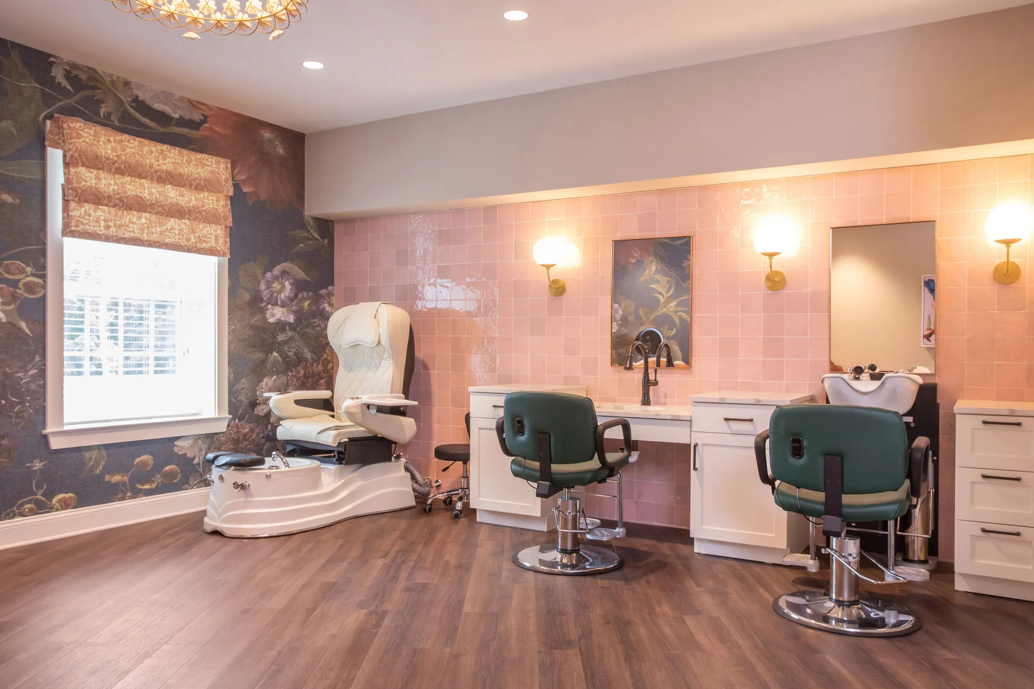 Senior living salon with green styling chairs and a shampoo bowl against pink tile and a dark floral mural