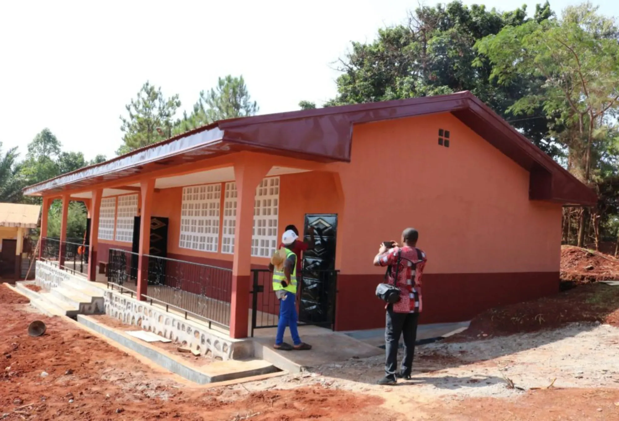 A newly finished terracotta and cream classroom block with a covered walkway, being photographed on the day it opened