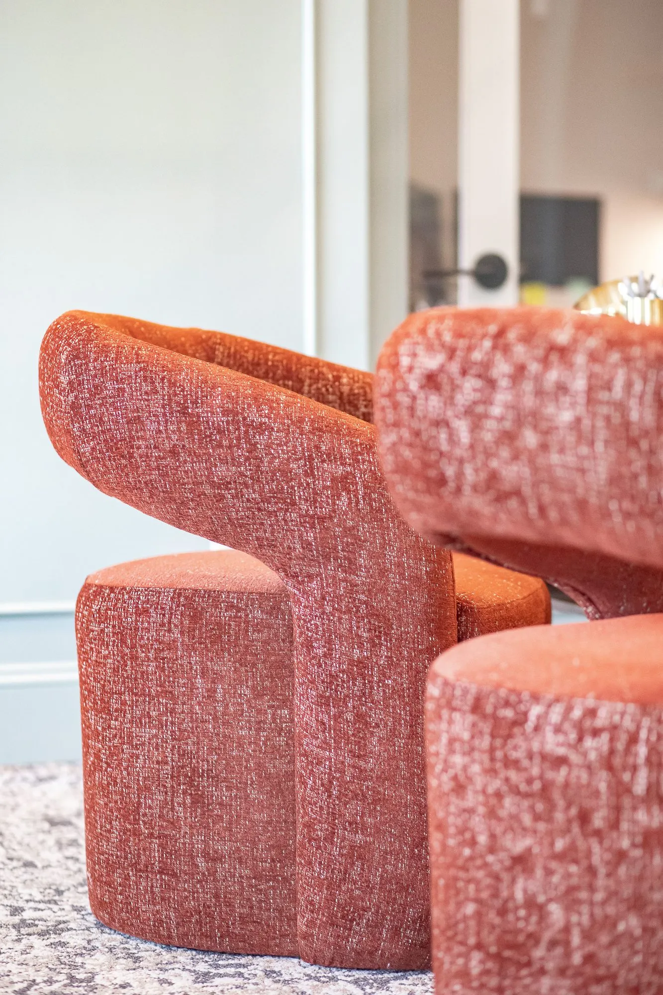 Multifamily amenity interior detail: two rust boucle swivel chairs