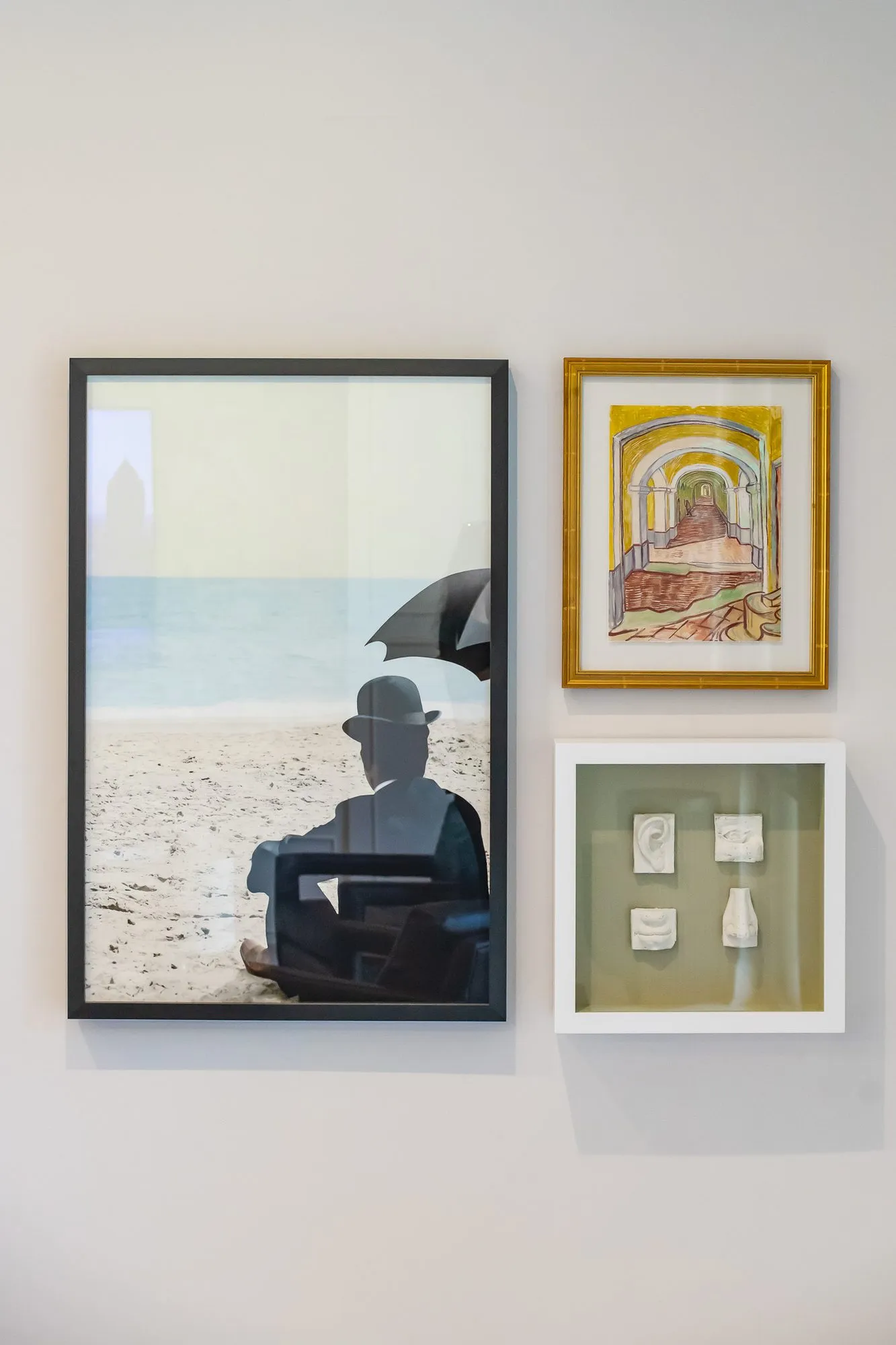 Multifamily interior detail: three framed artworks, the largest a photograph of a bowler-hatted figure on a beach