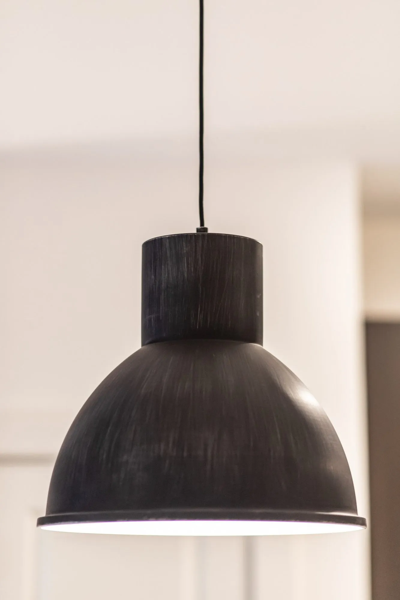 Multifamily amenity interior detail: black brushed metal dome pendant