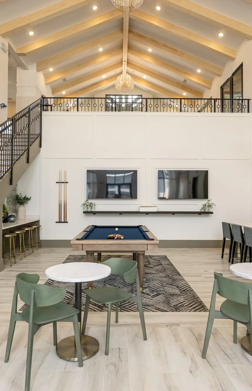 Multifamily clubhouse with pale rafters, a chevron tiled stair and a navy pool table, interior design by Banko Design at Crest at Acworth, Acworth, Georgia