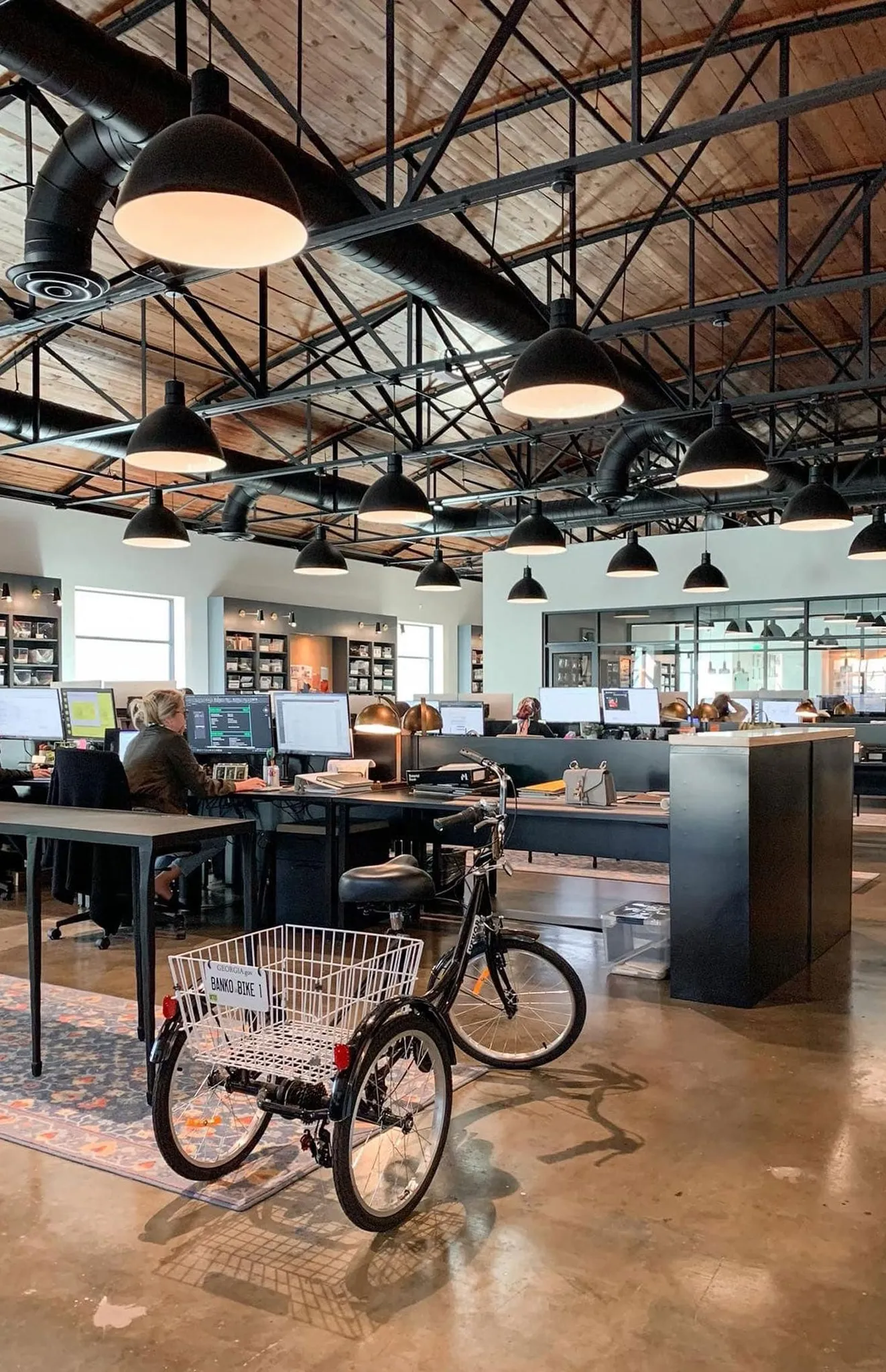 Office open studio under bowstring trusses and dome pendants, designers at their desks, interior design by Banko Design at Glover Street, Marietta, Georgia