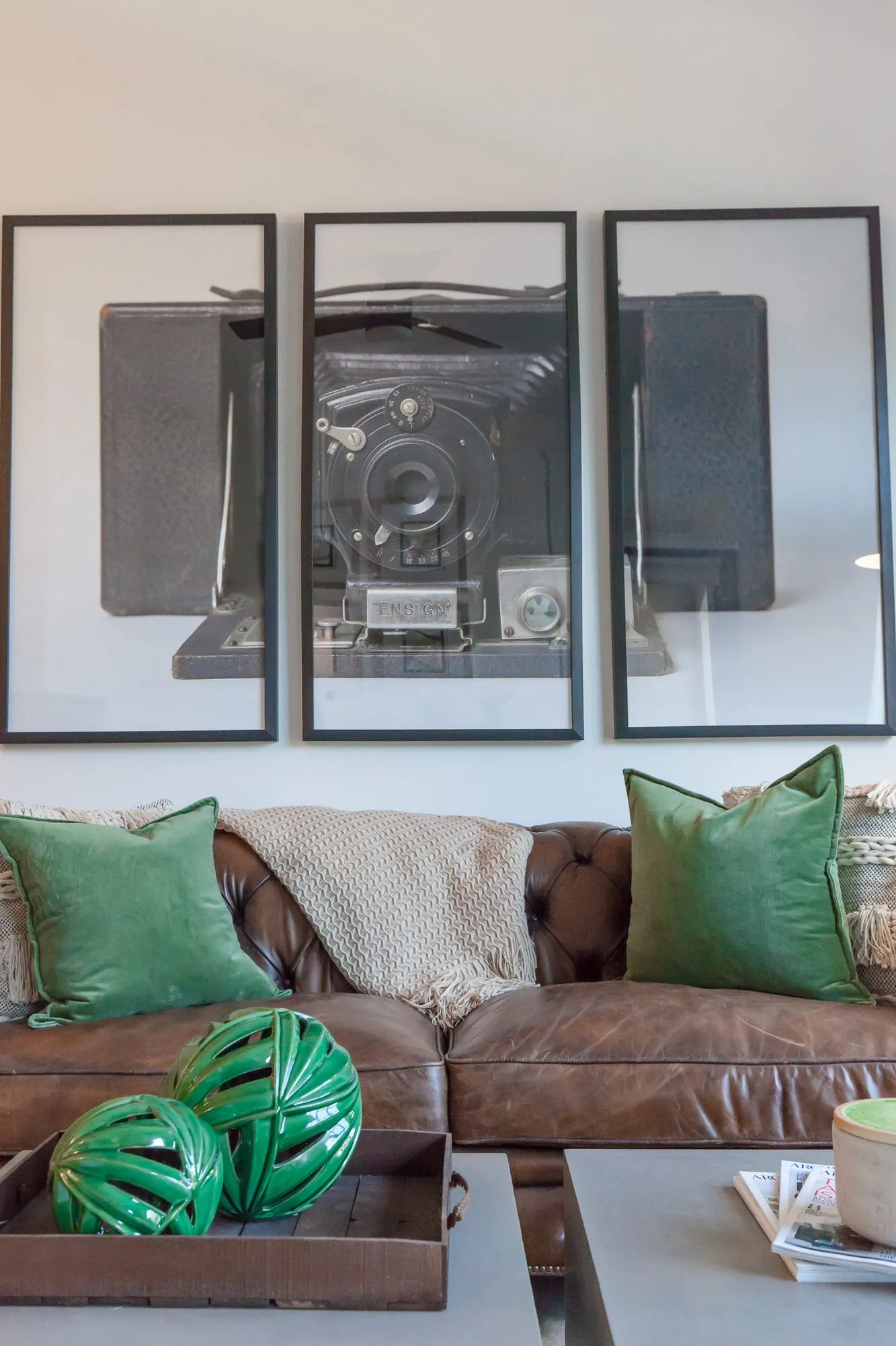 Multifamily interior detail: cognac tufted leather sofa with green velvet pillows, interior design by Banko Design at Harper on Piedmont, Atlanta, Georgia