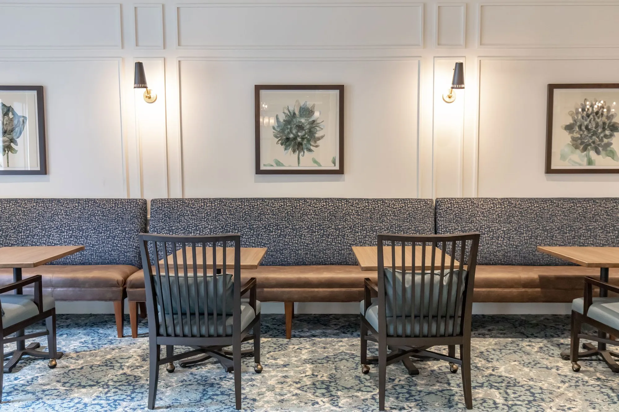 Senior living dining banquette in grey pattern and tan leather with slat back chairs, interior design by Banko Design at Madison Crossings, Madison, Alabama