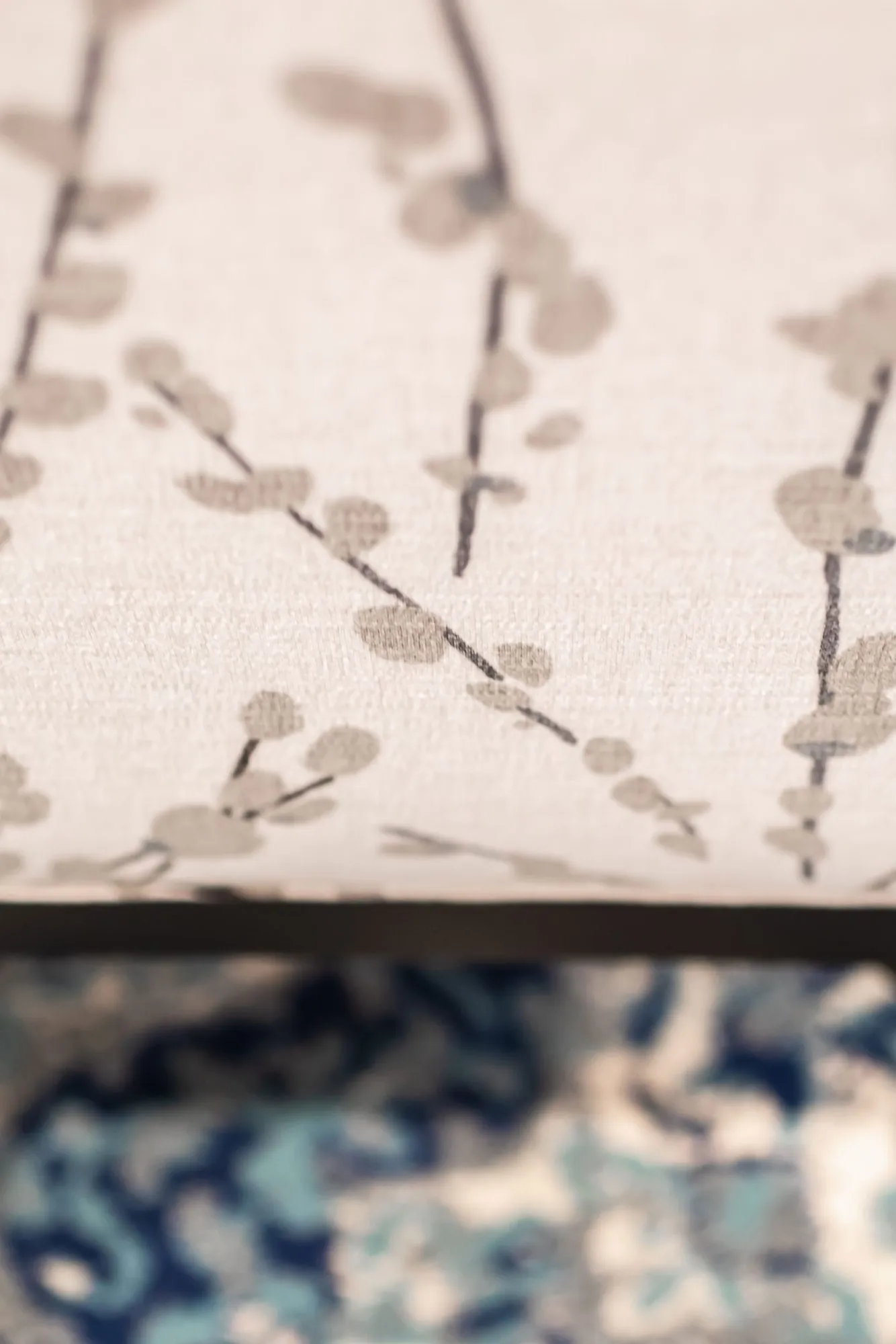 Senior living interior detail: cream fabric printed with grey blossom branches above a blue patterned fabric