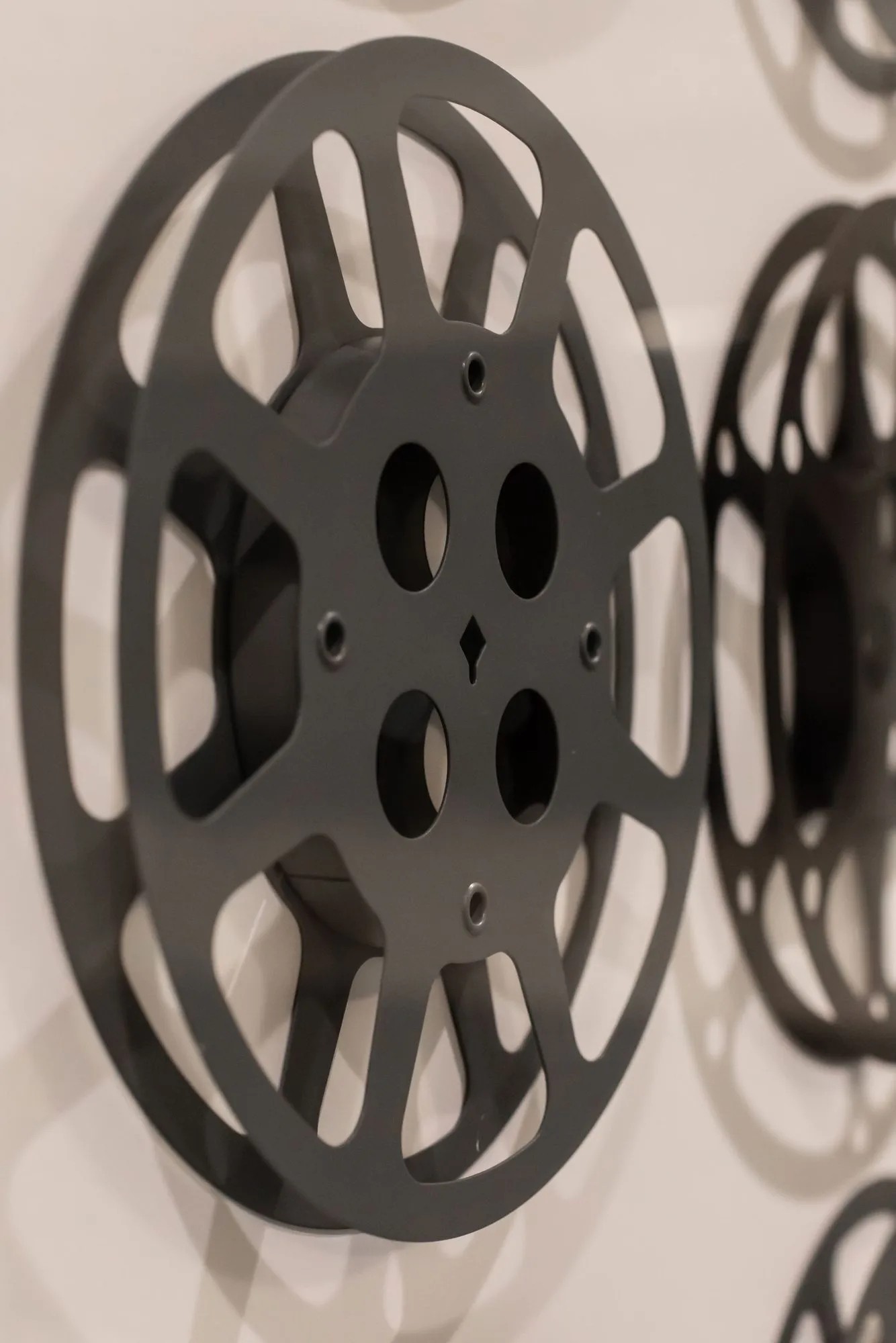 Senior living interior detail: black film reel wall art on a pale wall