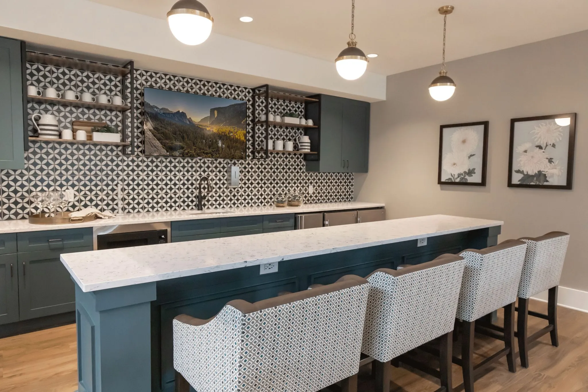 Senior living kitchen with black and white geometric tile behind a marble counter with patterned stools