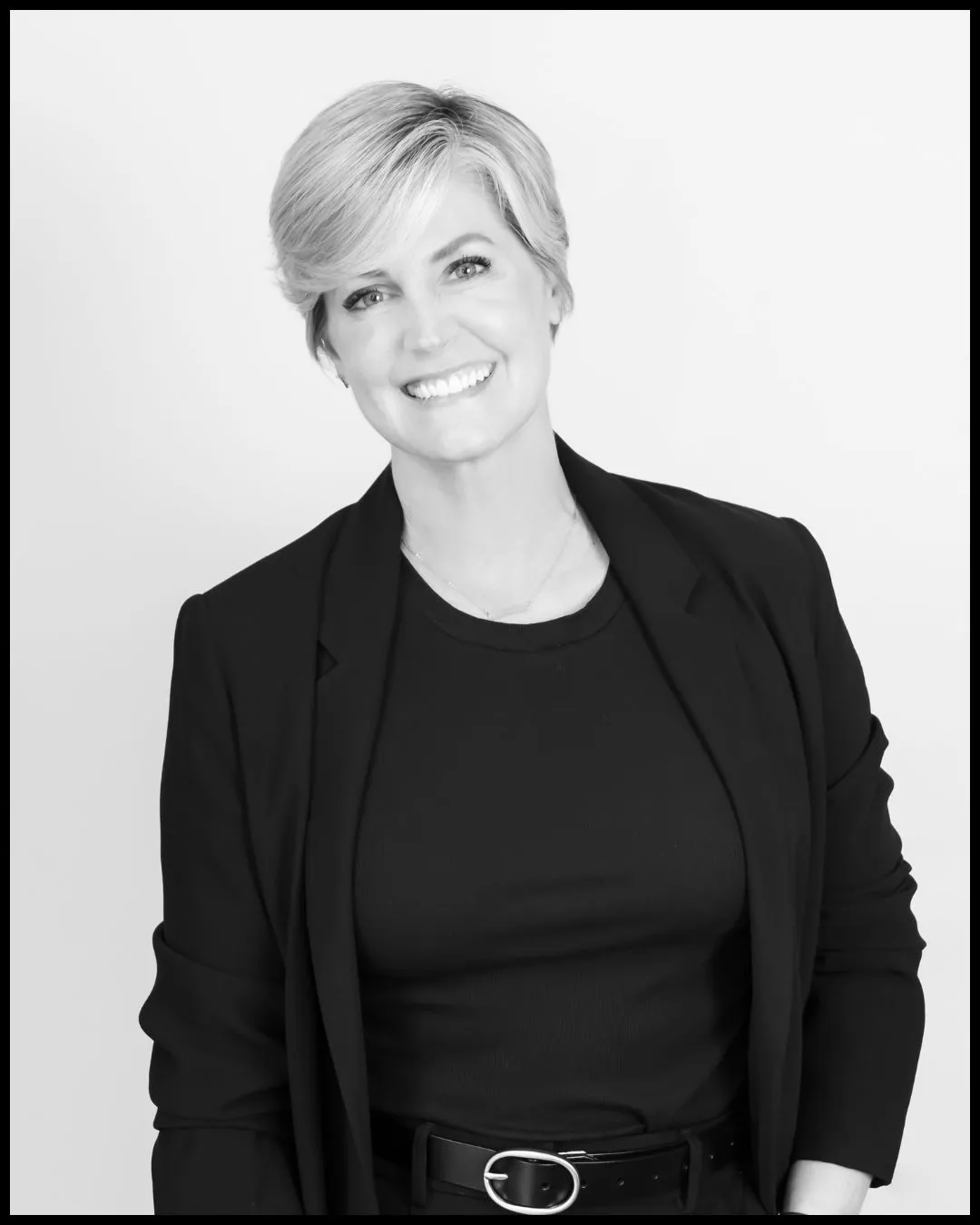 Melissa Banko in a black blazer, photographed in black and white against a plain studio backdrop