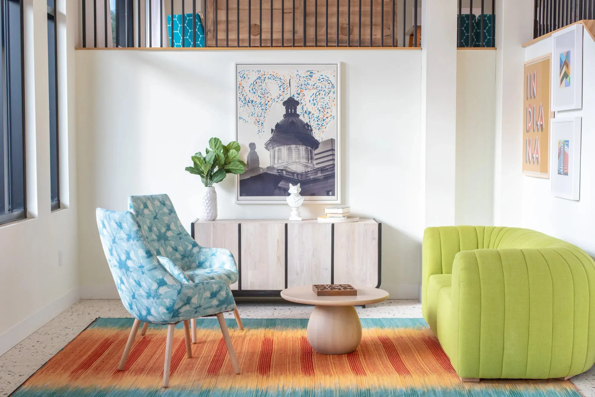 Multifamily amenity lounge with a chartreuse channel-tufted swivel chair and a blue tie-dye armchair on a striped rug