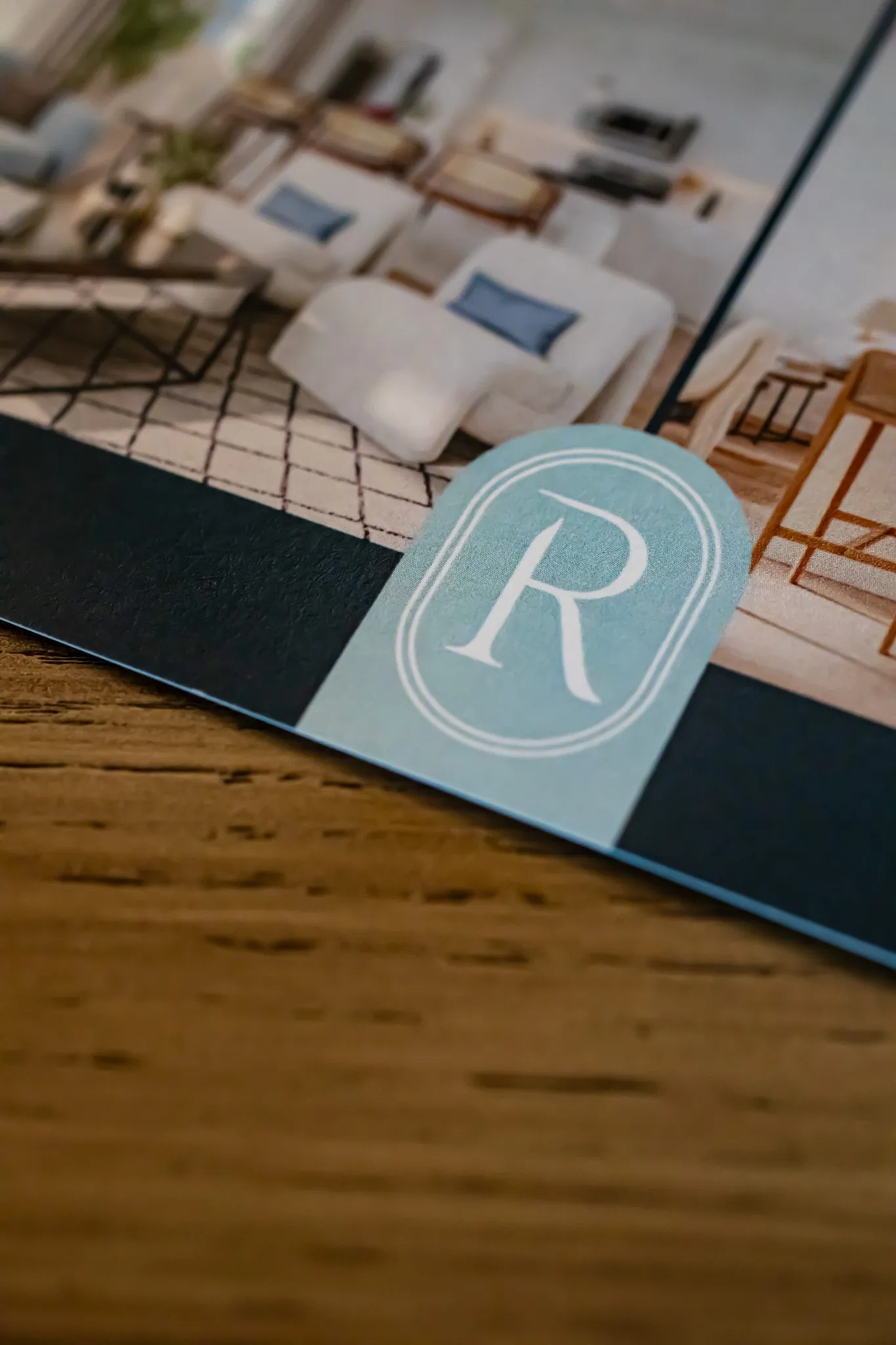 Multifamily leasing collateral: printed materials with a monogram tab resting on a wood table