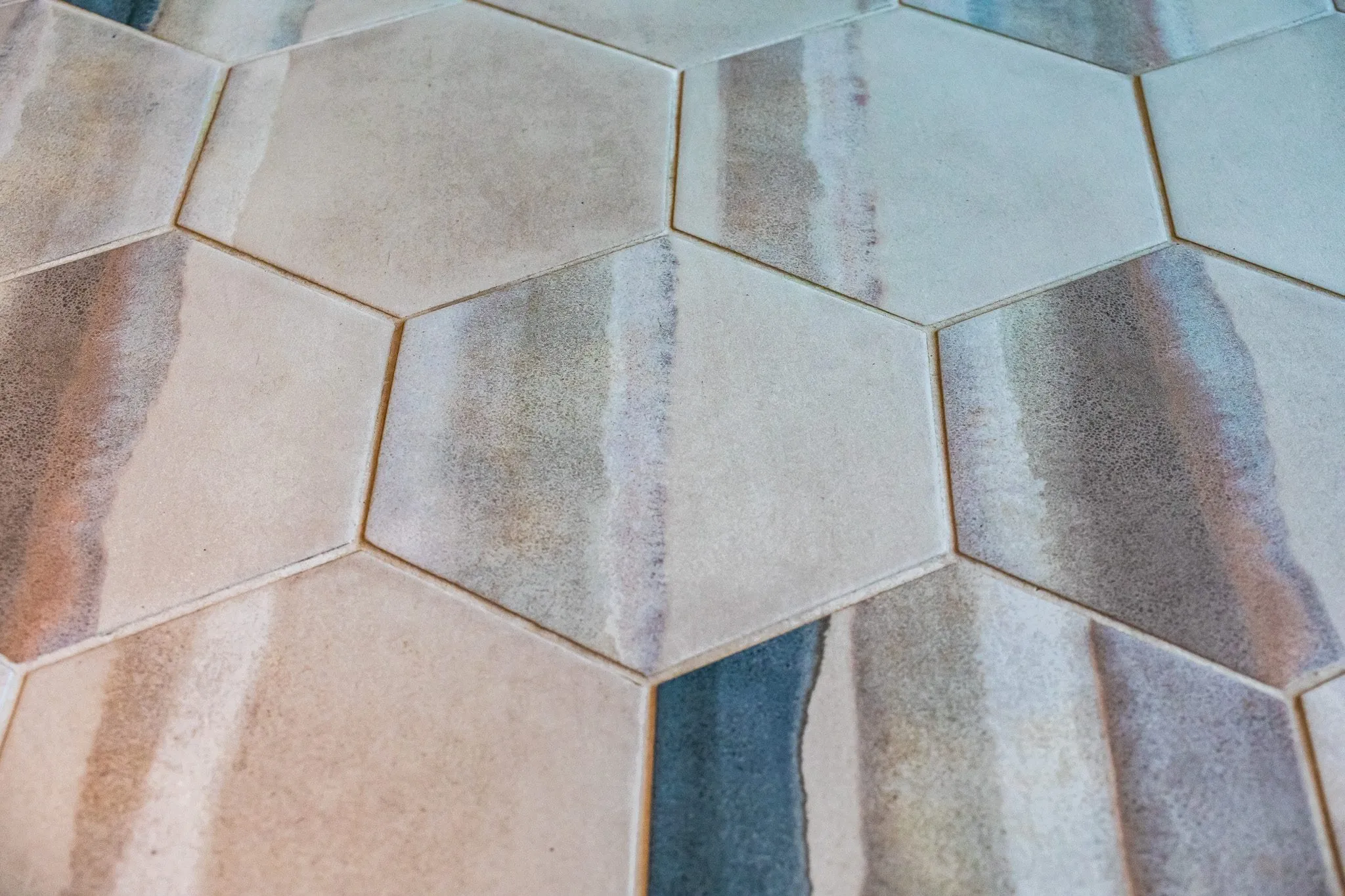 Multifamily interior detail: hexagon floor tile glazed in sand, grey and blue watercolor tones