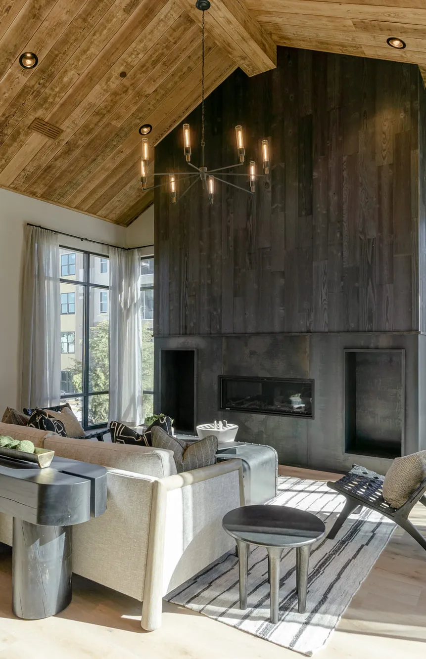 Multifamily clubroom under a plank vaulted ceiling with a charred wood chimney, interior design by Banko Design at Oslo Apartments, Fairburn, Georgia