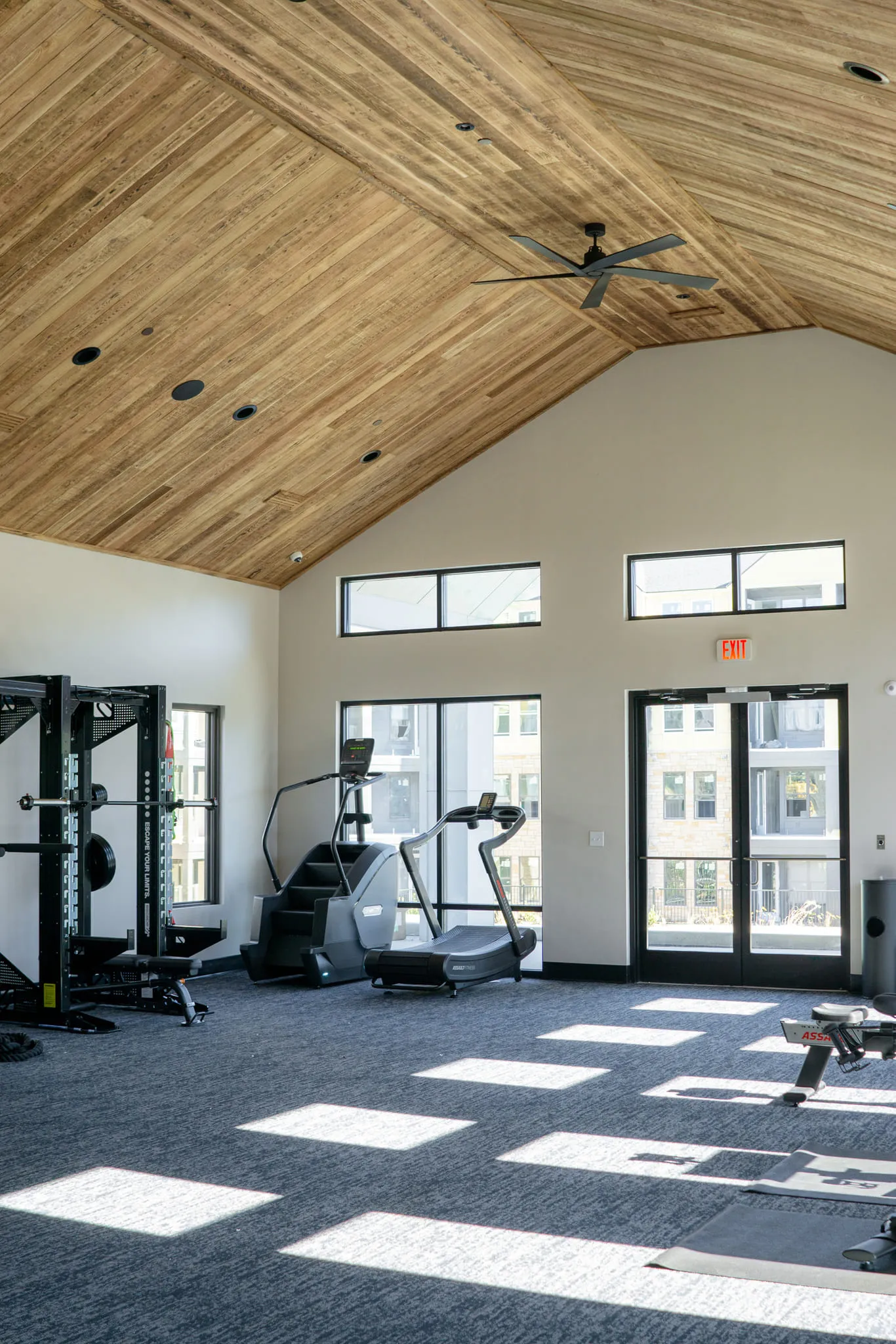 Multifamily amenity fitness center with a weight rack and cardio equipment, interior design by Banko Design at Oslo Apartments, Fairburn, Georgia