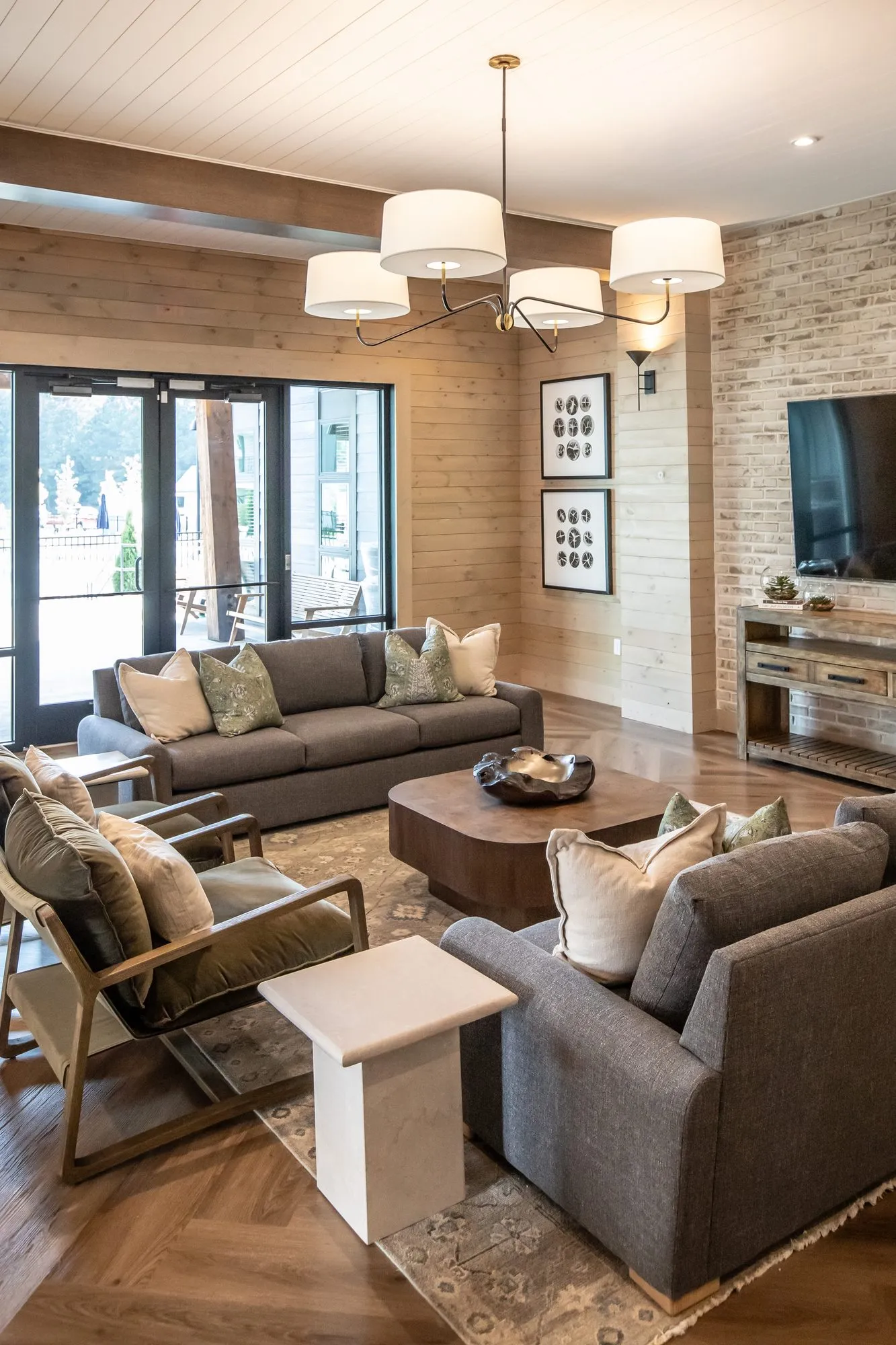 Multifamily amenity lounge with grey sofas around a round coffee table, interior design by Banko Design at Crofthouse West Cobb, Powder Springs, Georgia
