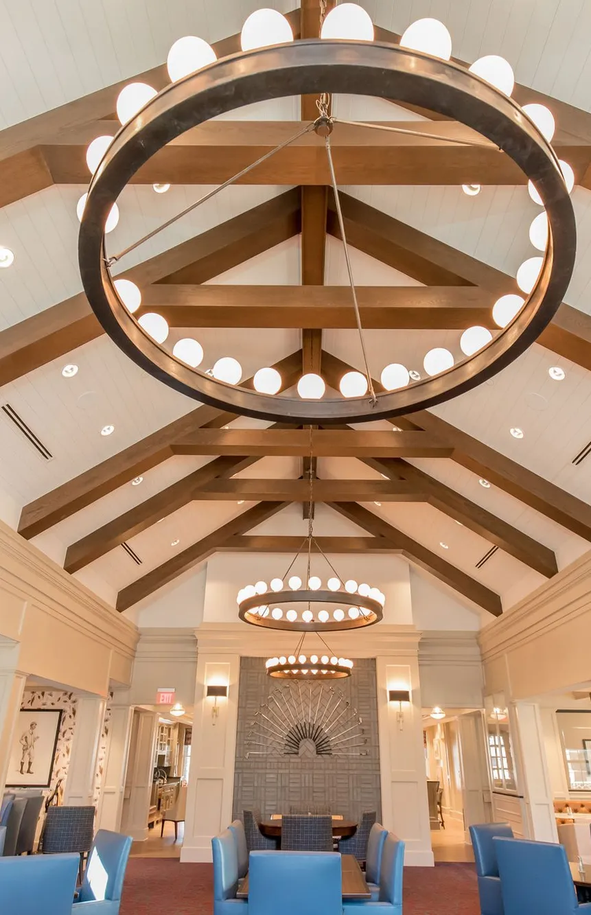 Senior living dining room with timber trusses and ring chandeliers, interior design by Banko Design at The Phoenix at Braselton, Hoschton, Georgia