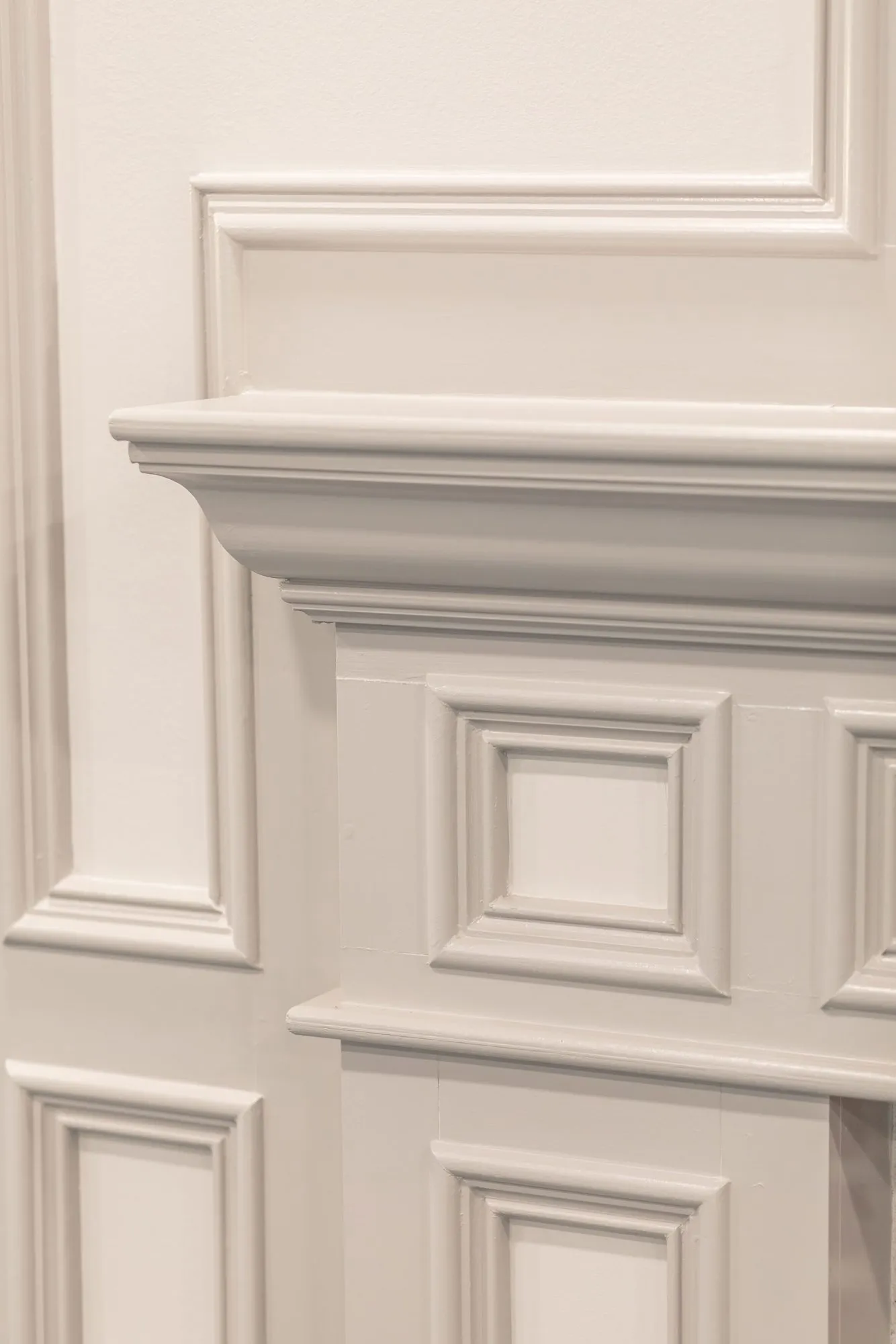 Senior living interior detail: white panelled millwork at the corner of a fireplace mantel