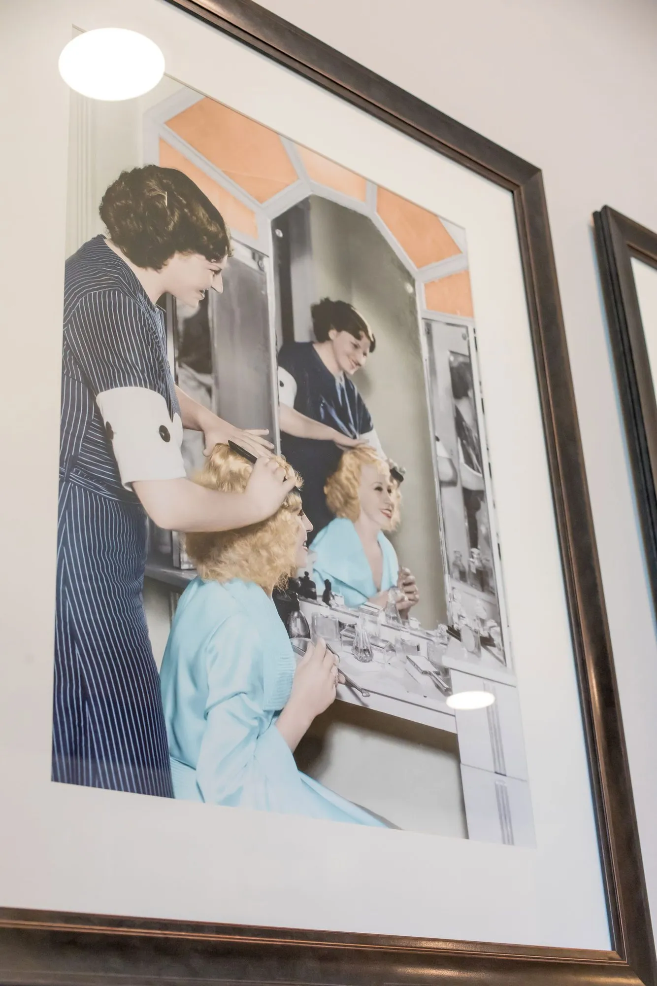 Senior living interior detail: framed vintage photograph of a stylist setting a woman's hair at a salon mirror