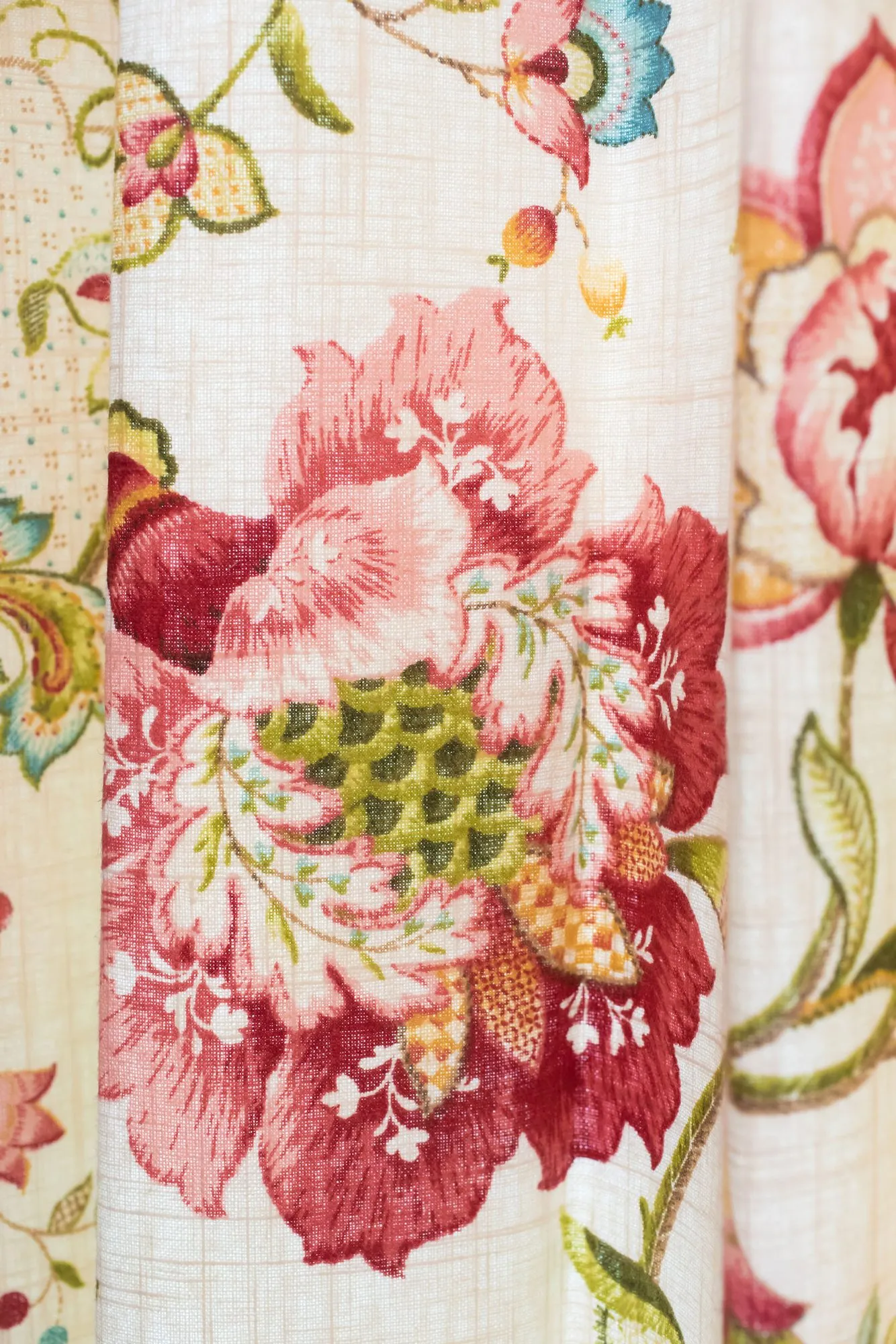 Senior living interior detail: drapery in a large pink and red floral print on cream