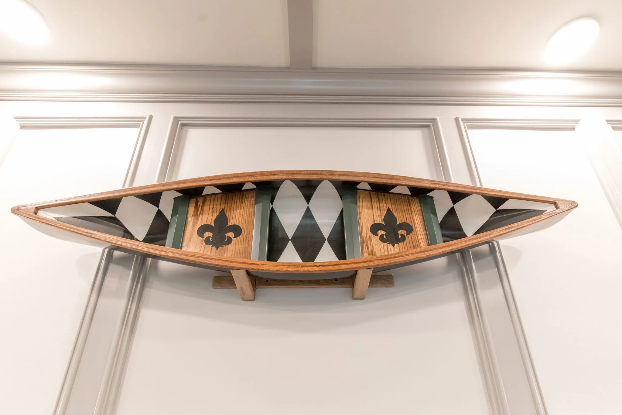 Senior living interior detail: decorative canoe with its interior painted in harlequin diamonds and fleur-de-lis