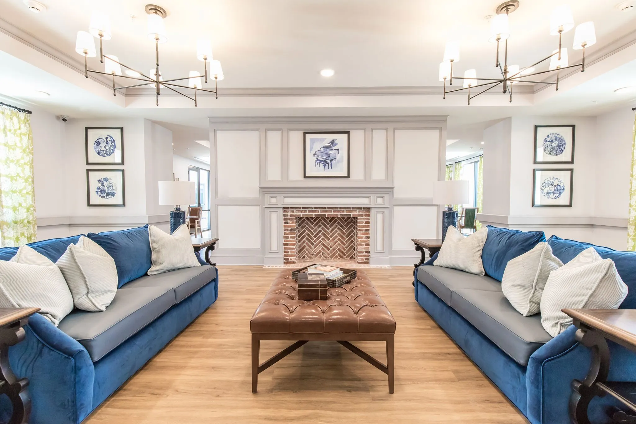 Senior living living room with navy velvet sofas either side of a herringbone brick fireplace