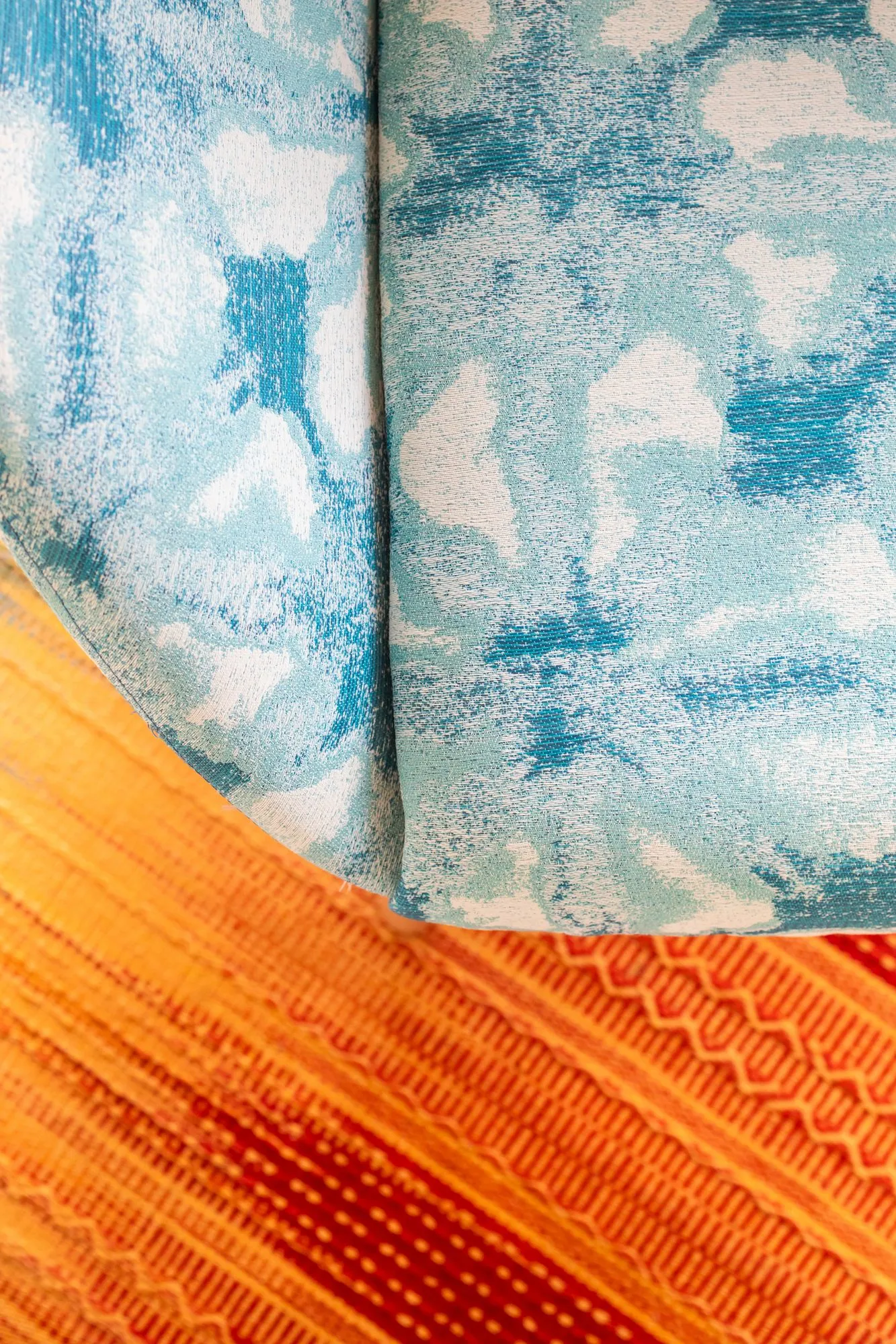 Student housing interior detail: blue and white mottled upholstery against an orange and red patterned textile