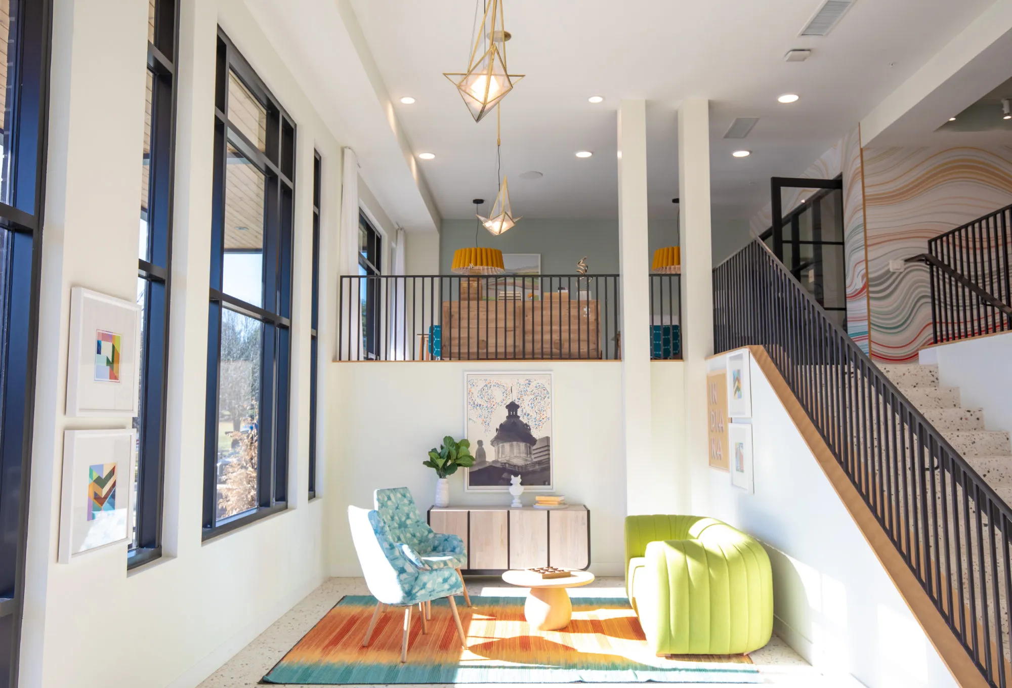 Student housing amenity lobby at Relato Apartments with black-framed windows, terrazzo, a chartreuse chair and a wavy pastel stair wall