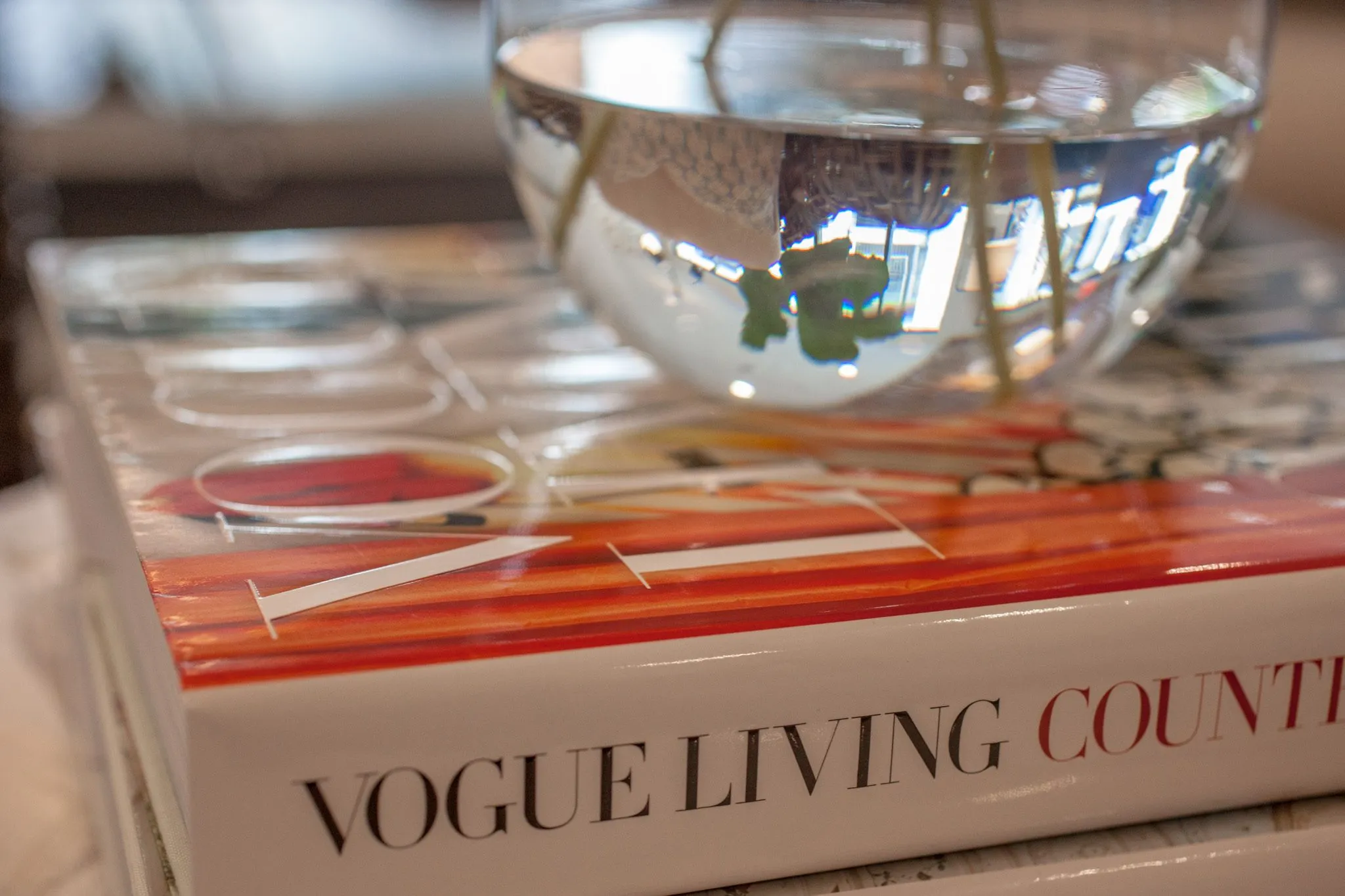 Multifamily interior detail: glass bowl vase resting on a coffee table book