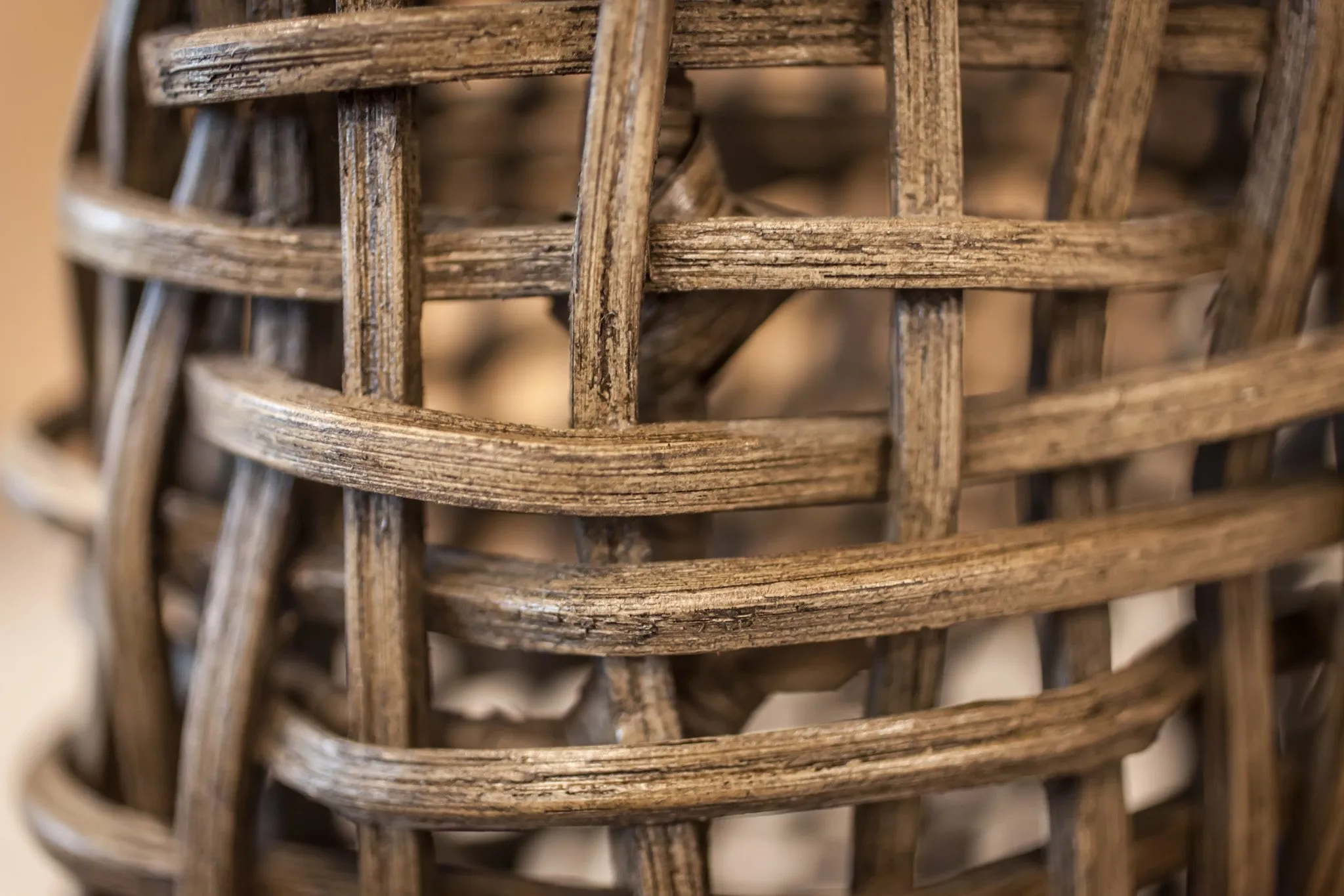 Multifamily interior detail: weathered rattan weave of a lounge chair
