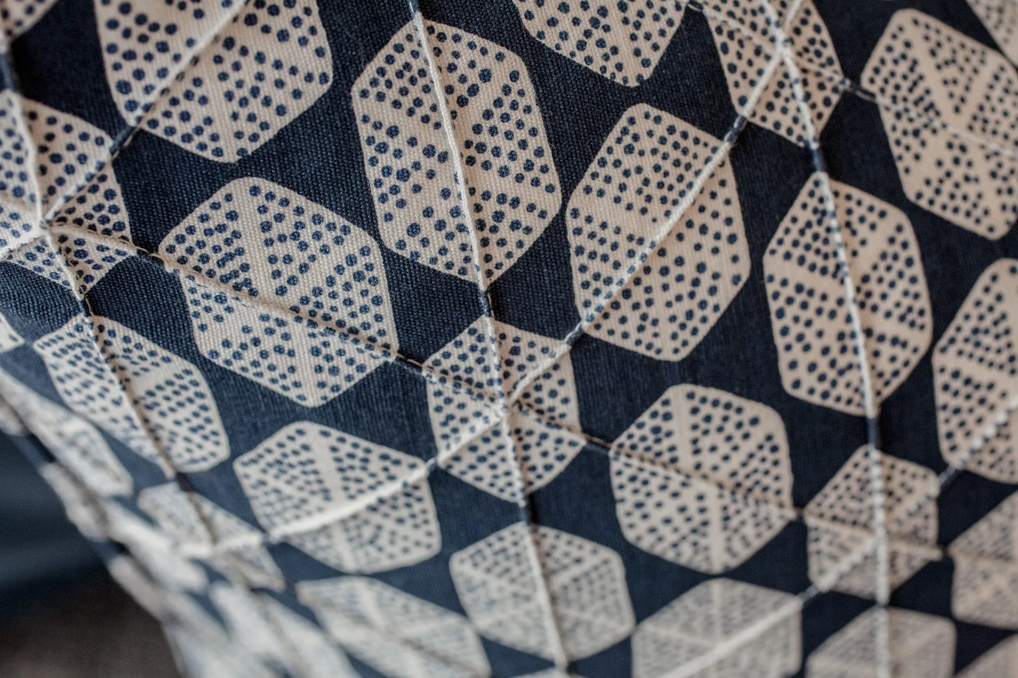 Multifamily interior detail: navy upholstery printed with dotted cream hexagons