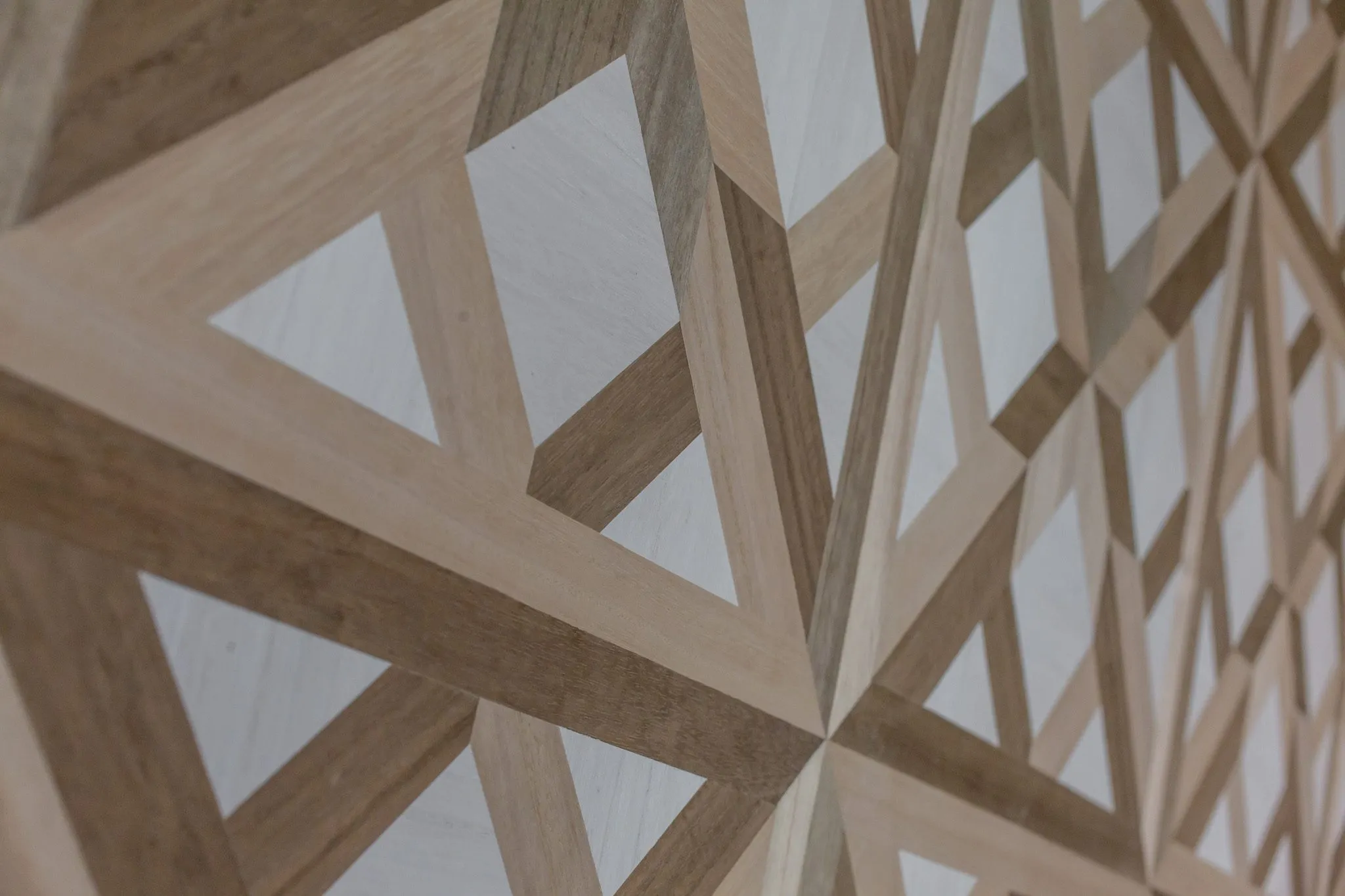 Multifamily interior detail: geometric wood veneer wallcovering in light and dark tones, at an angle