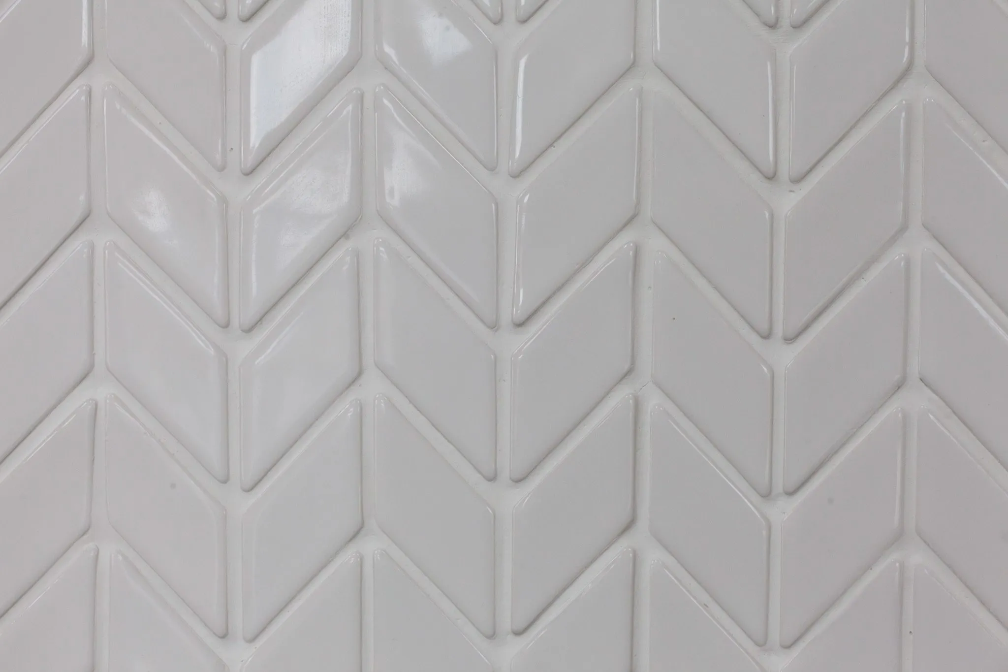 Multifamily interior detail: white chevron tile with a glossy glaze
