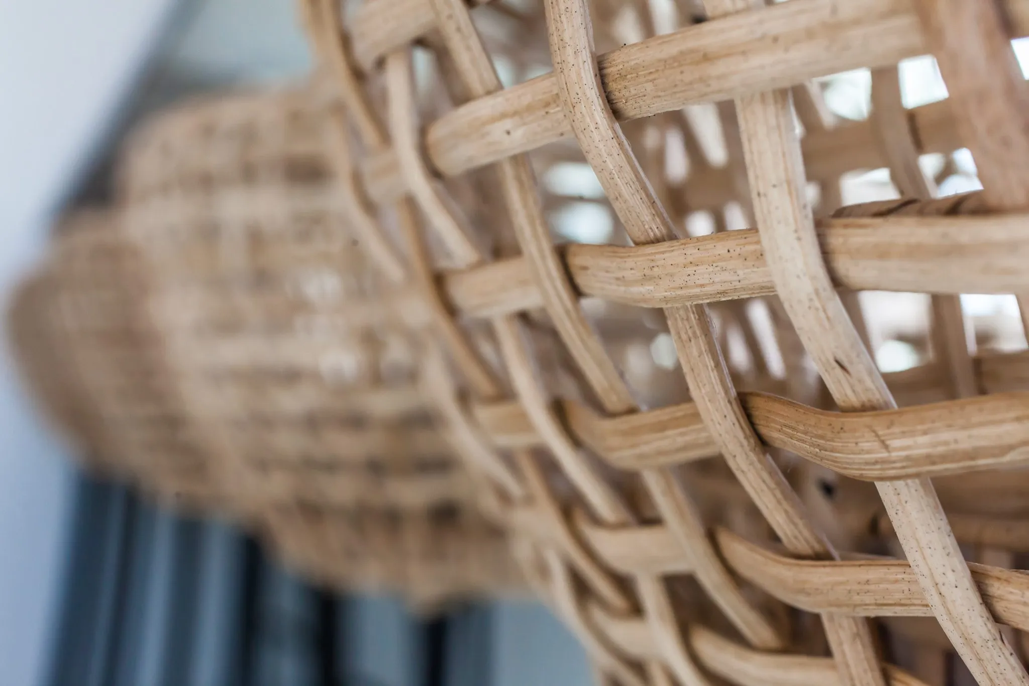 Multifamily interior detail: open rattan weave of a pendant shade