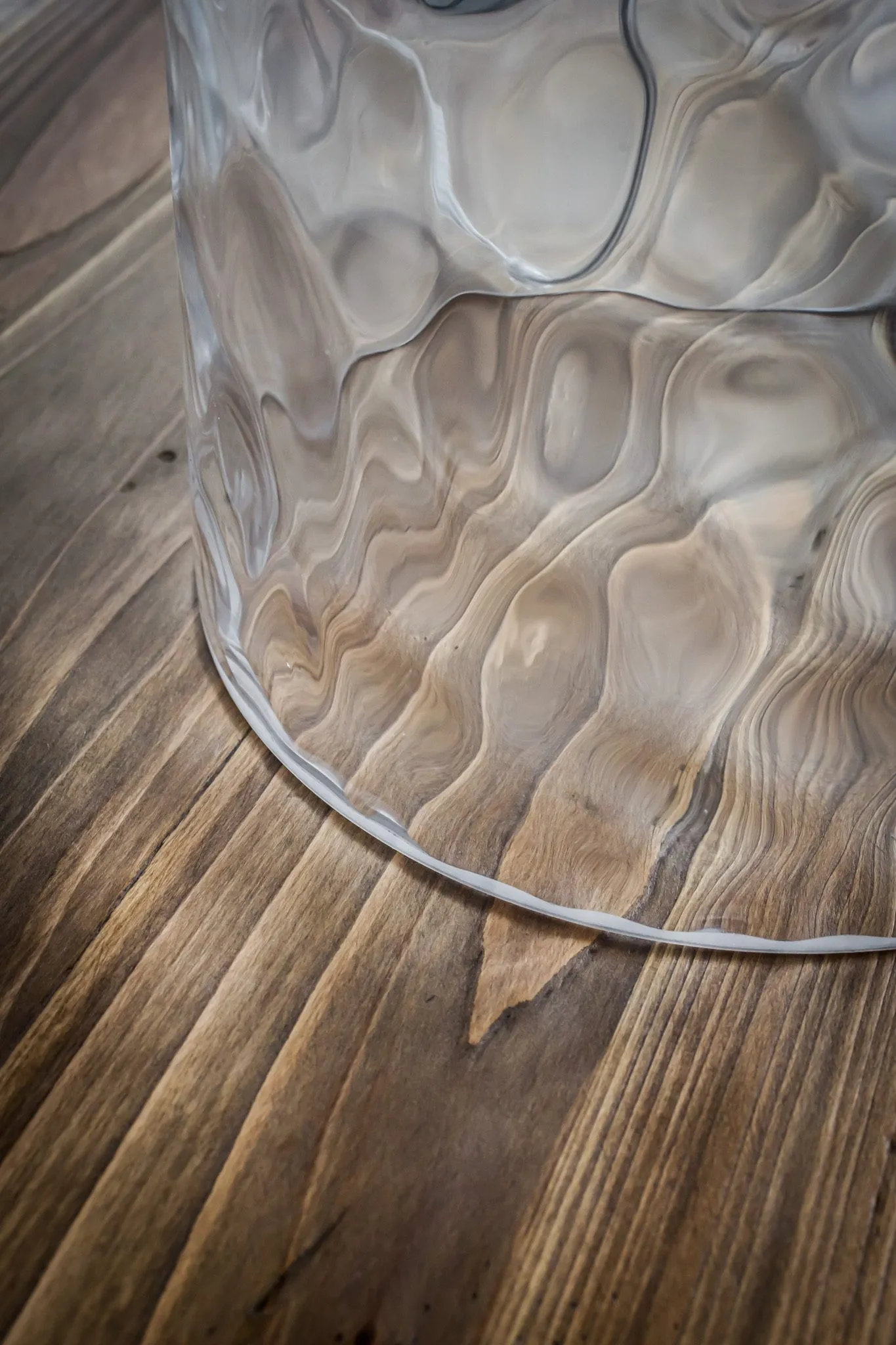 Multifamily interior detail: textured glass lamp base on a wood side table