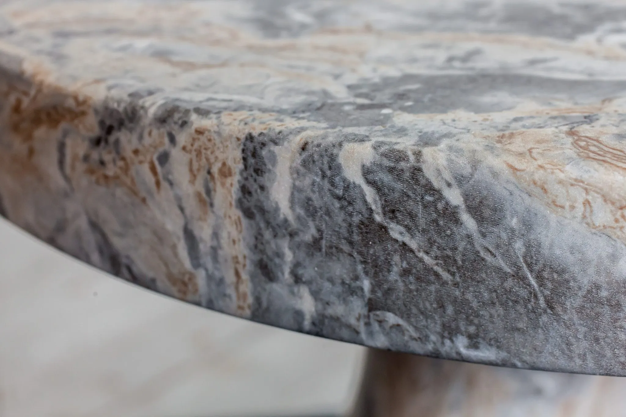 Multifamily interior detail: grey and rust veined marble edge of a side table