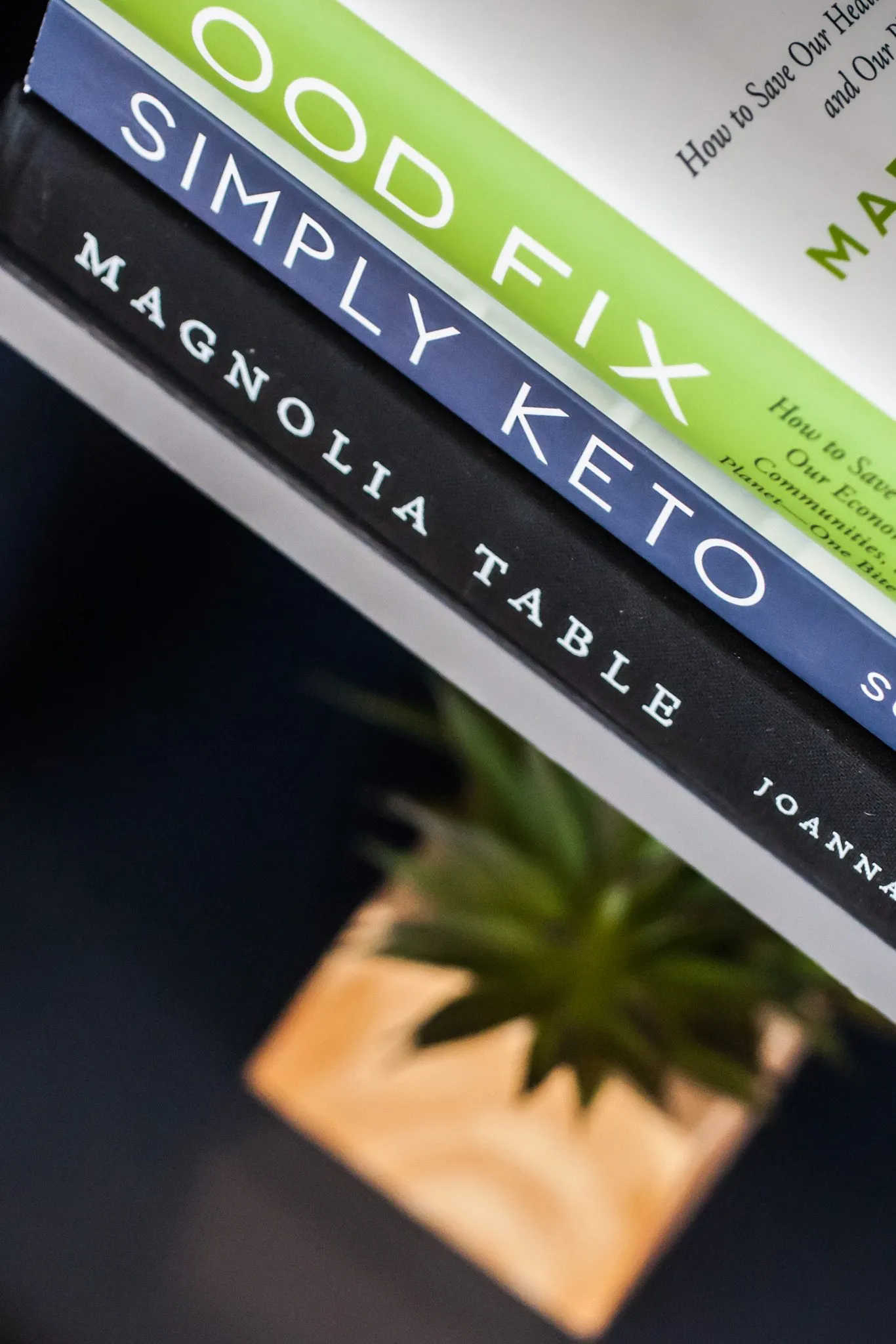 Multifamily interior detail: cookbook spines stacked on a shelf above a small potted succulent