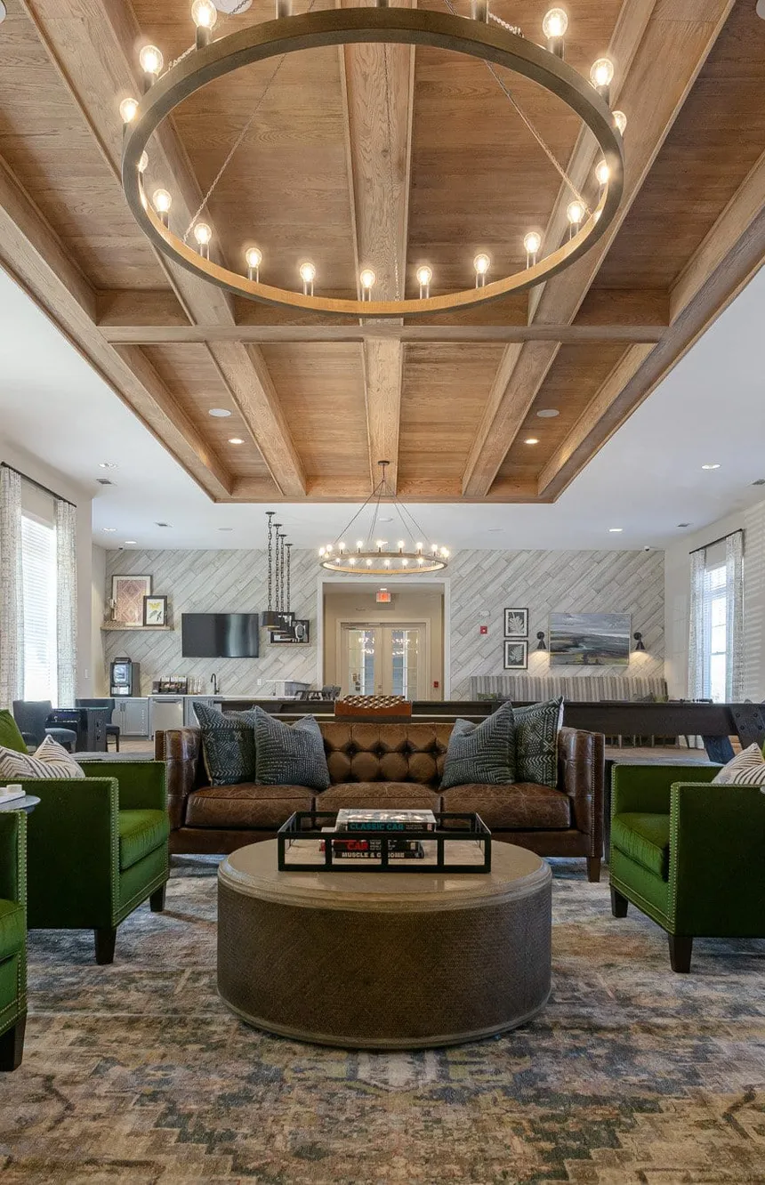 Multifamily amenity clubroom under an oak coffered ceiling and a wood ring chandelier, interior design by Banko Design at South & Twenty, Cartersville, Georgia