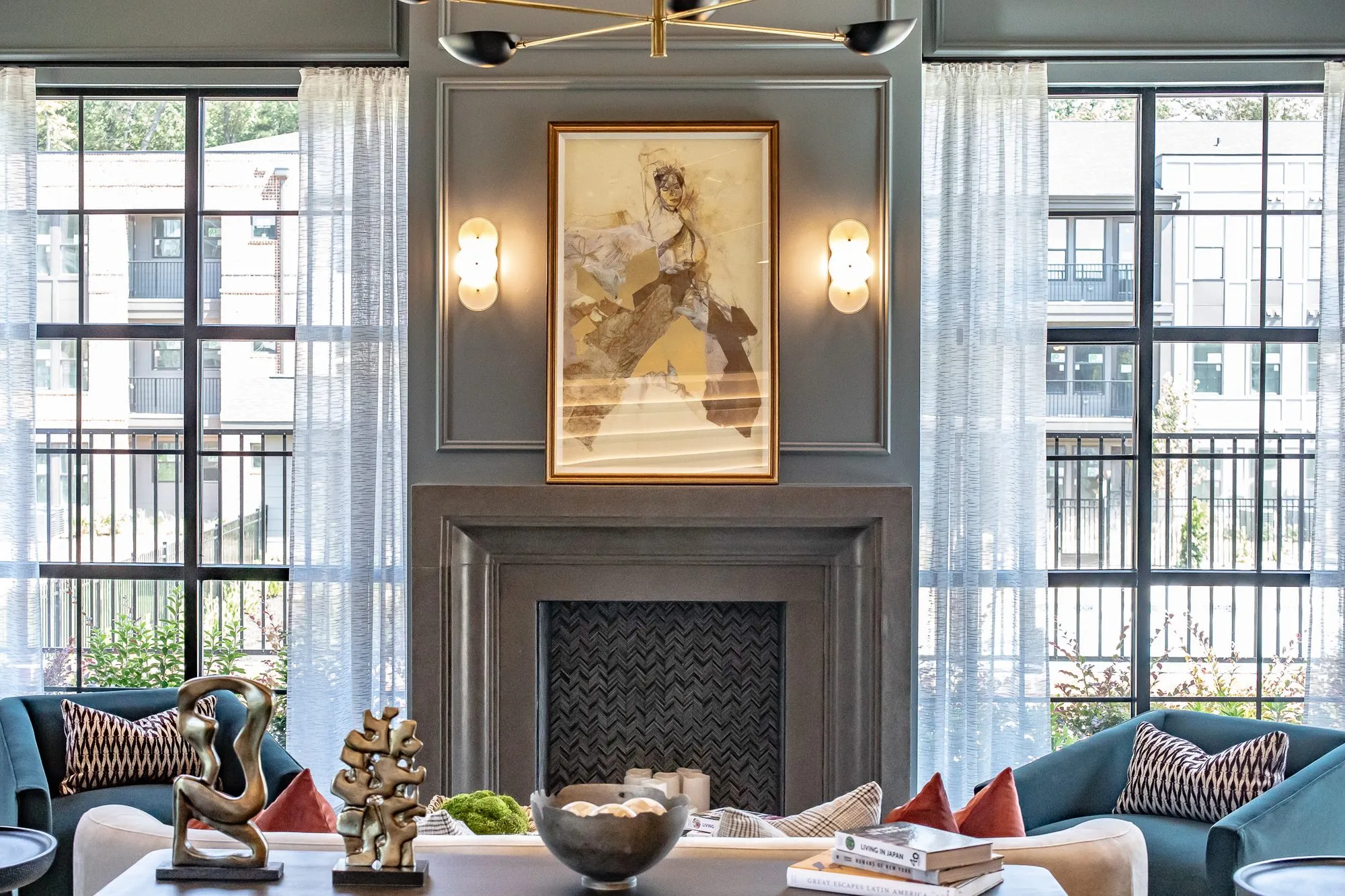 Clubroom at Chastain Hill, blue velvet sofas facing a marble fireplace hung with an equestrian painting, between tall casement windows